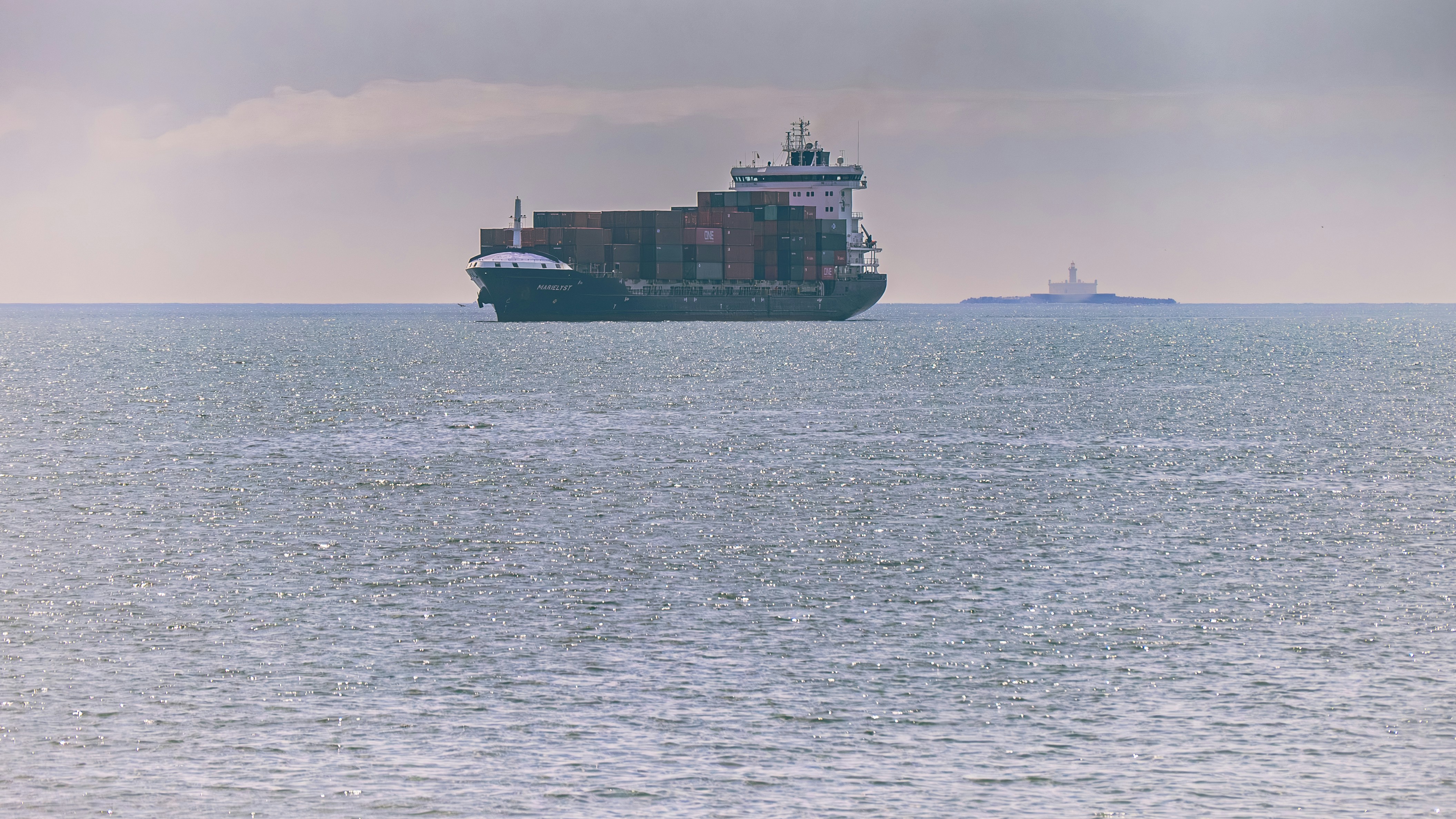Cargo ship sailing on the ocean near island