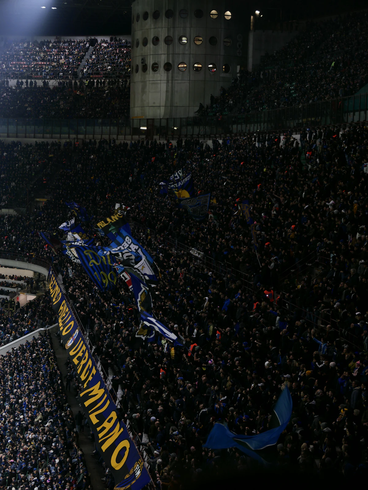 Dramatic atmosphere with crowd of fans and flags at a stadium at night