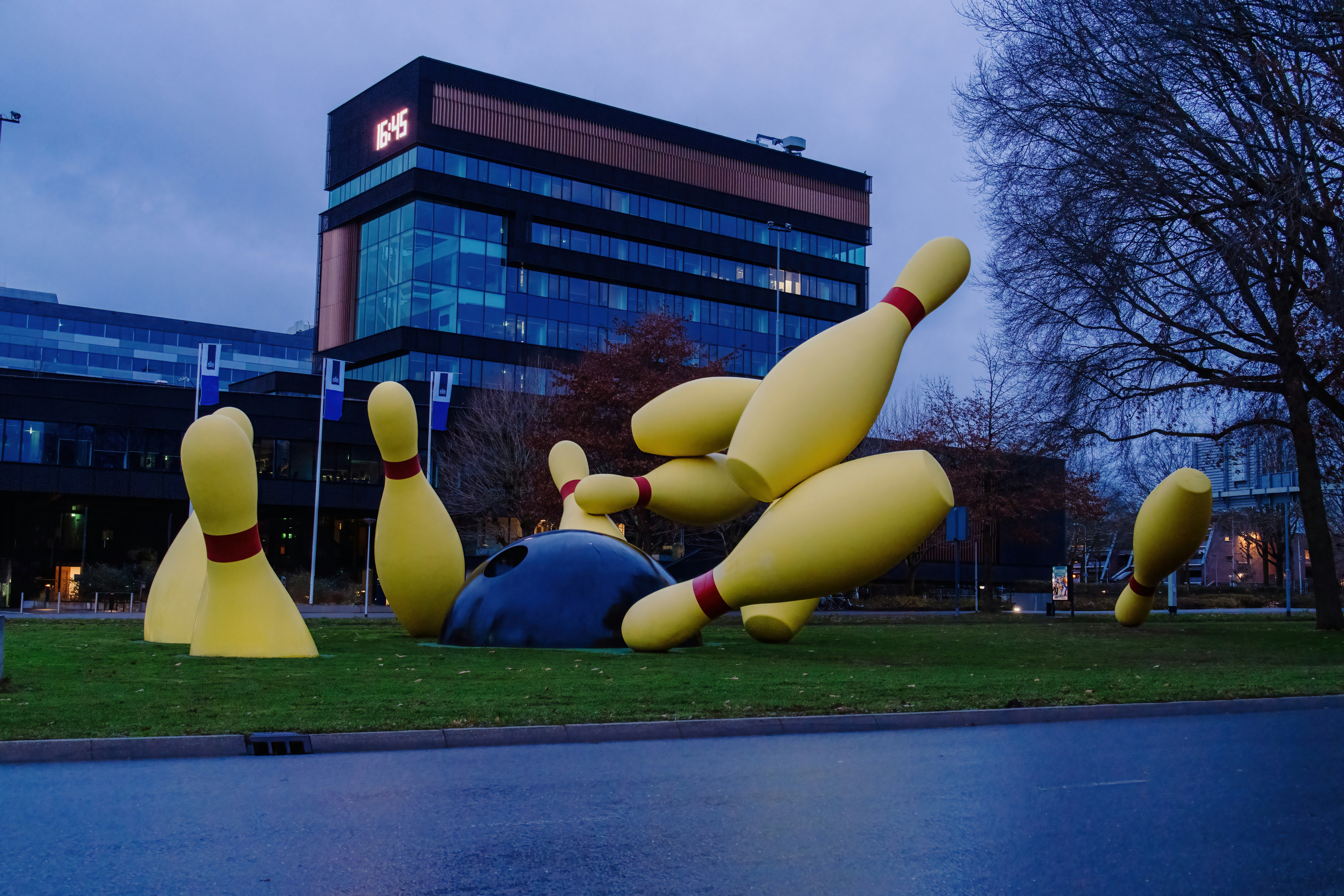 Giant bowling pins scattered on grassy area