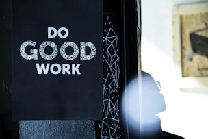 Do good work sign on black background with person silhouette