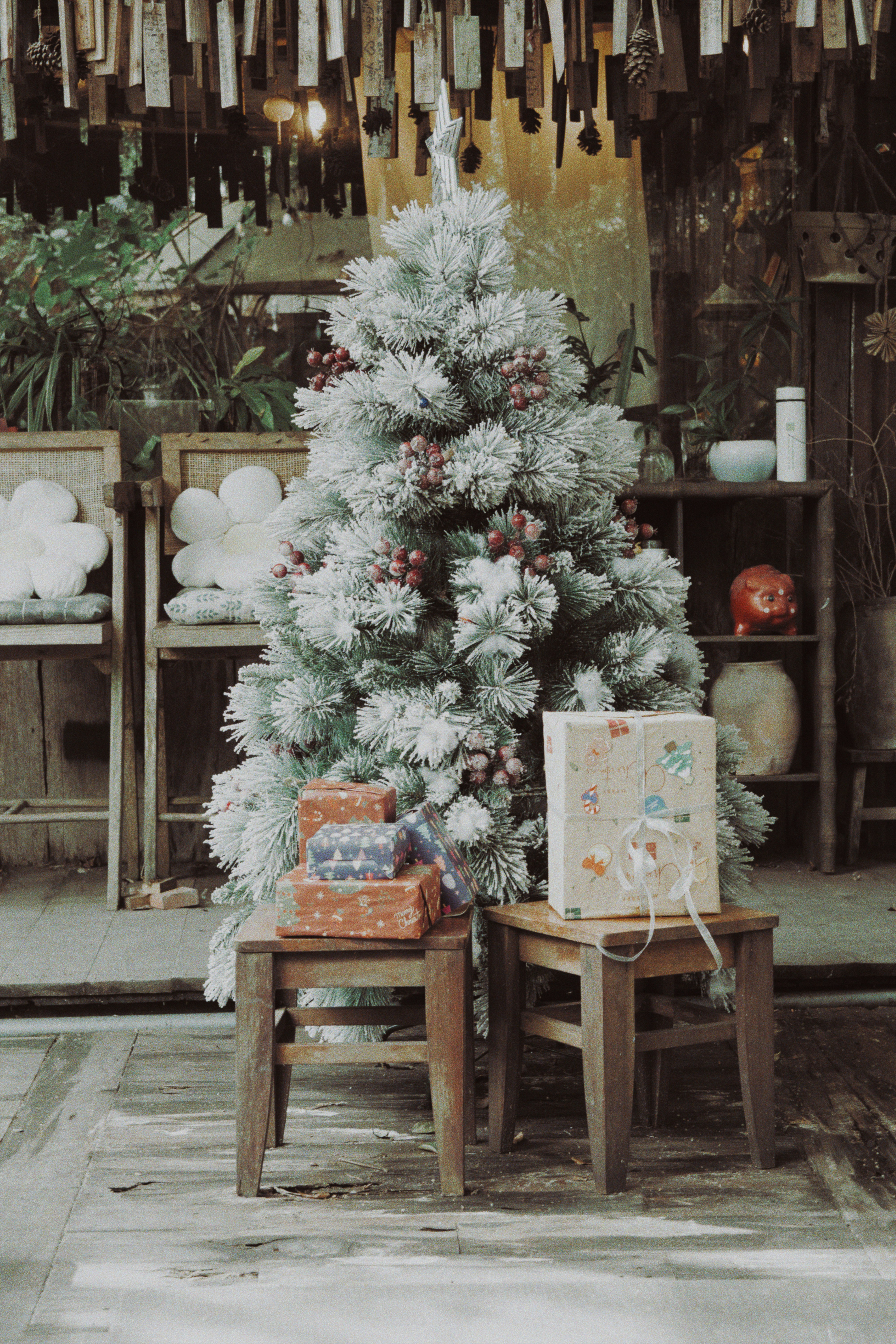 Frosted christmas tree with gifts on stools