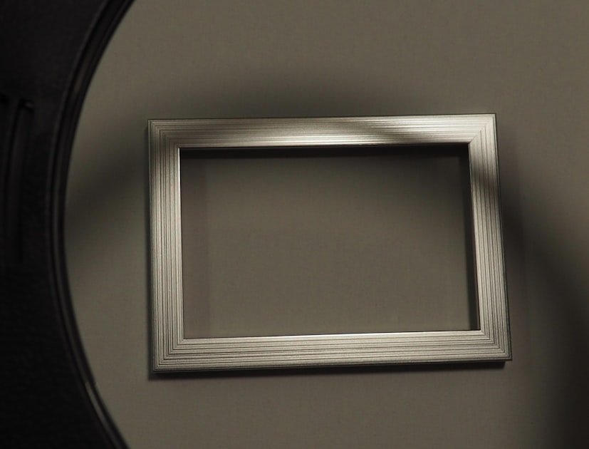 Empty silver picture frame on a wall.