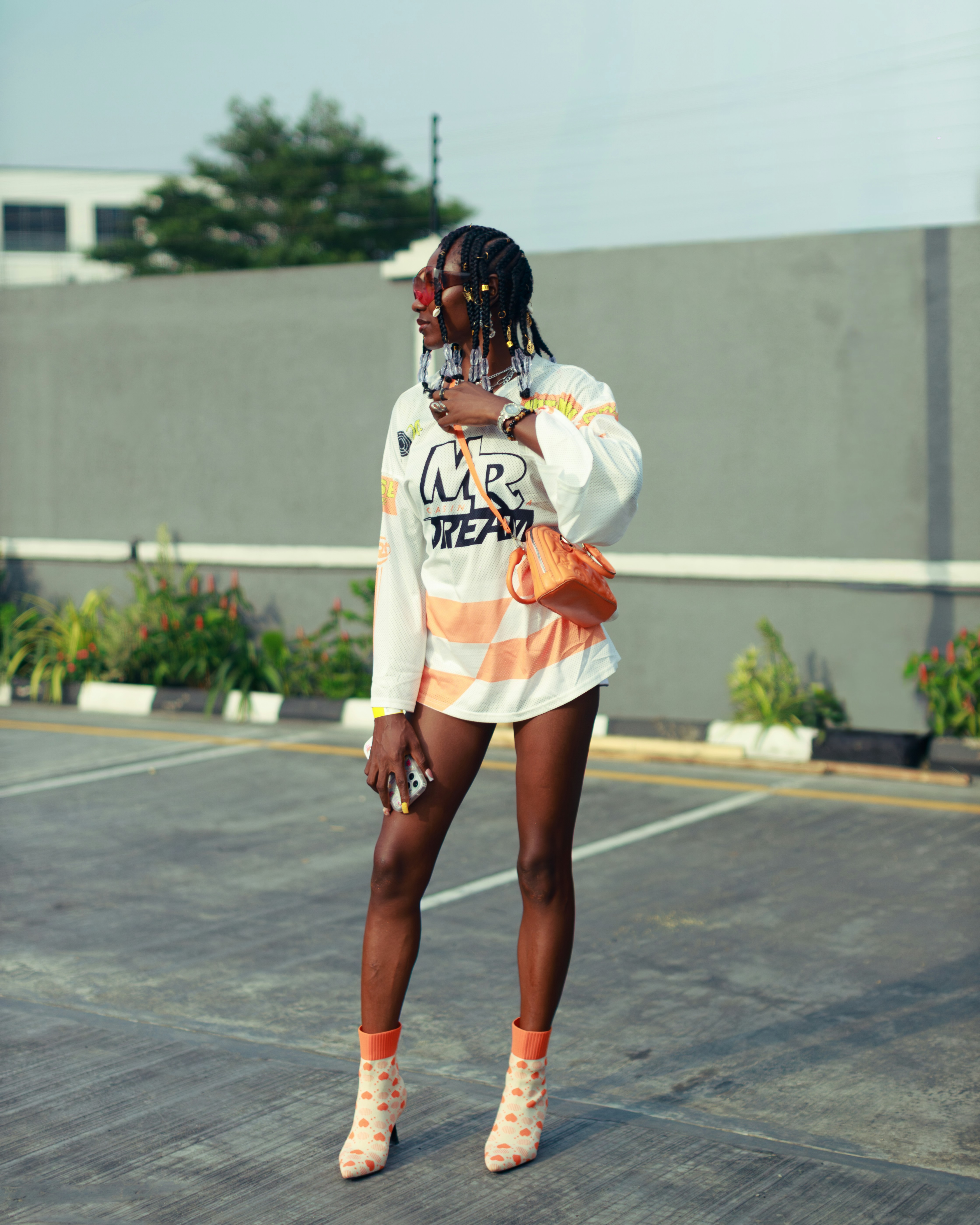 Woman in stylish outfit posing in parking lot