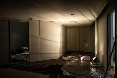 A dimly lit room with a figure on the floor.