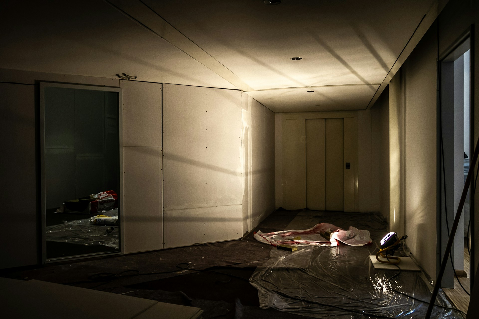 A dimly lit room with a figure on the floor.