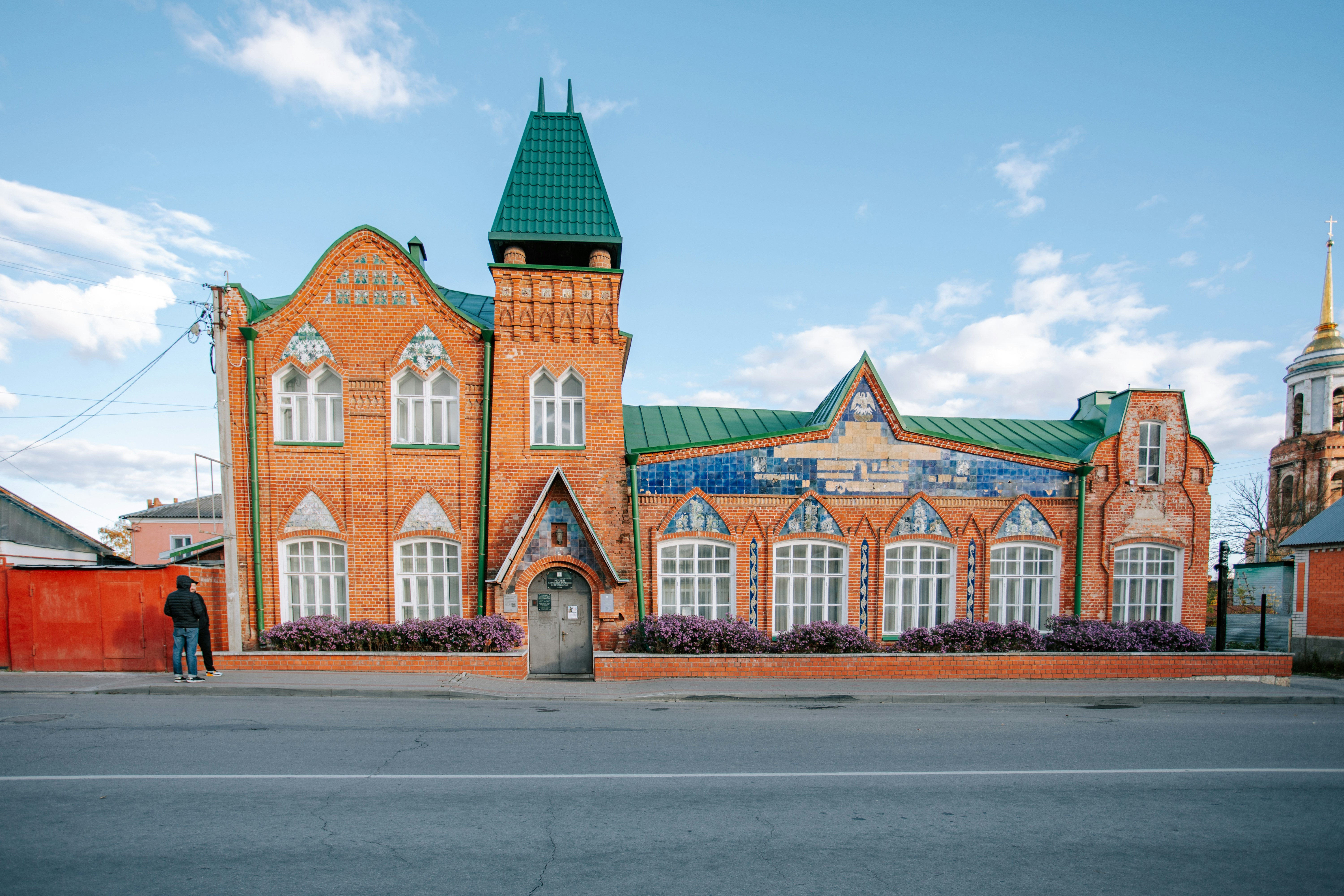 Ornate brick building with green roof and tower