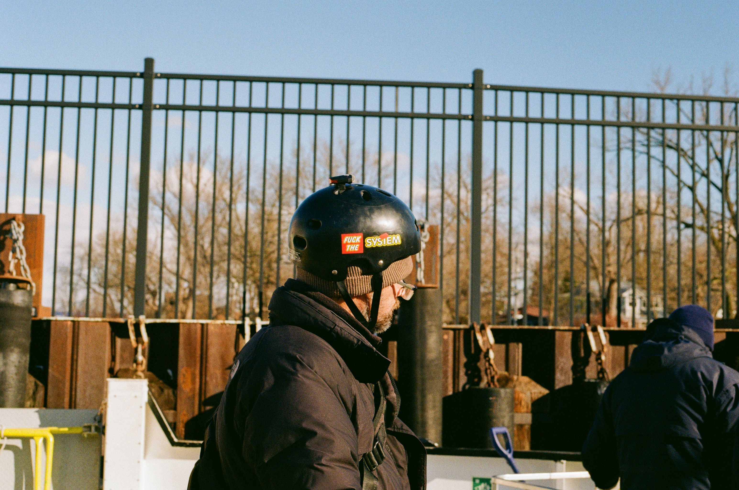 Man wearing a helmet with stickers on-camera equipment.