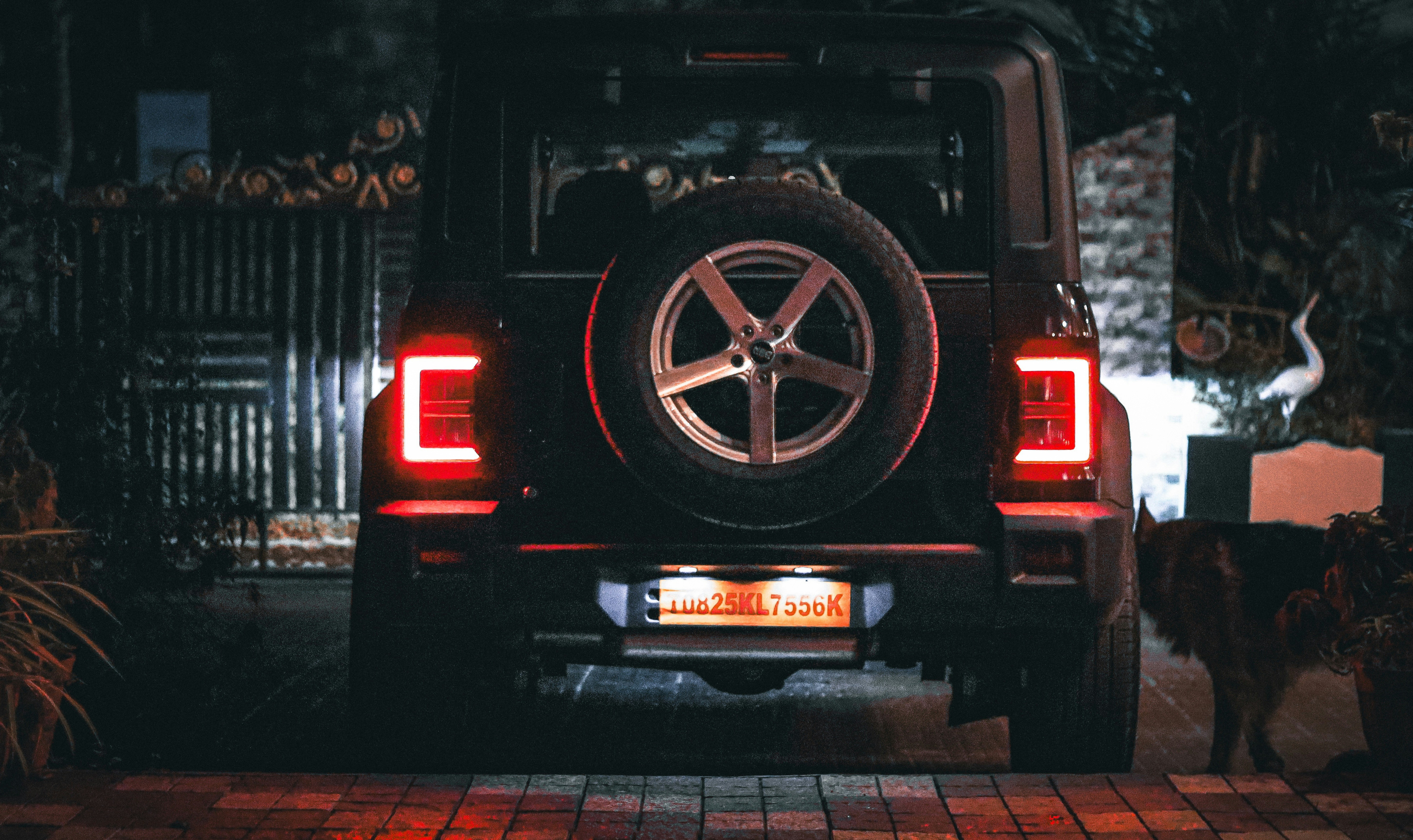 Black suv parked at night with illuminated taillights