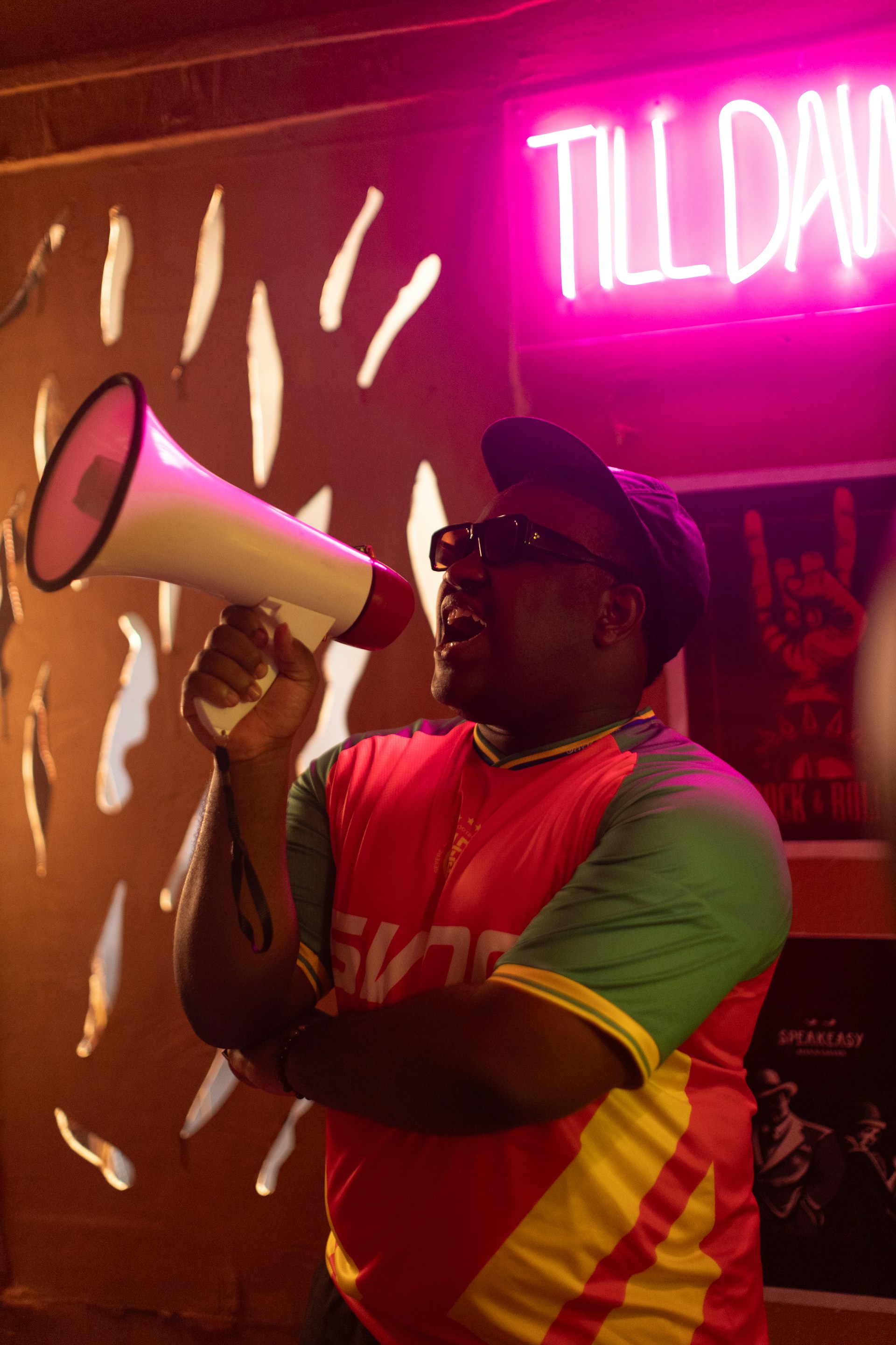 Man with megaphone under neon sign