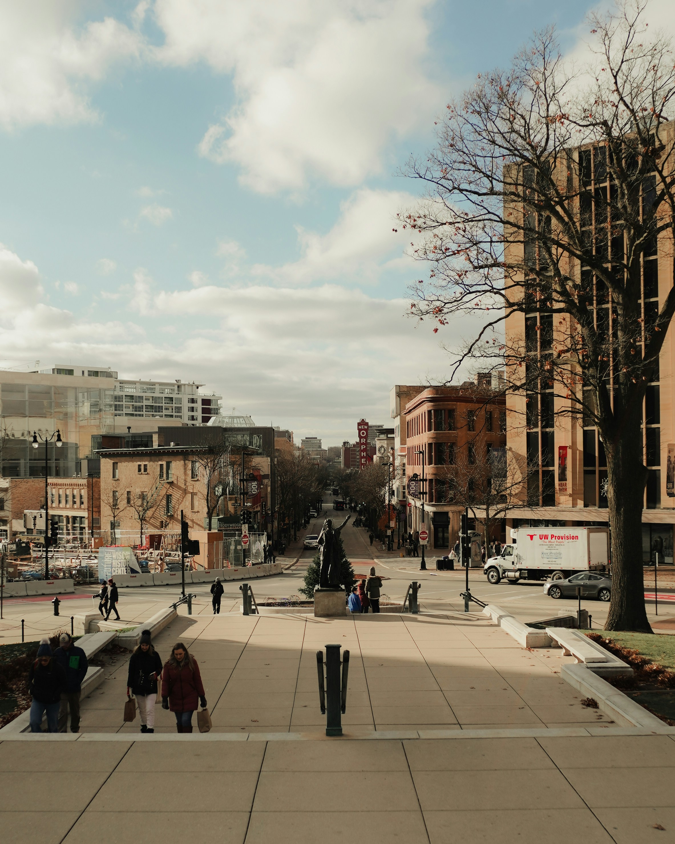 People walking up stairs towards city buildings