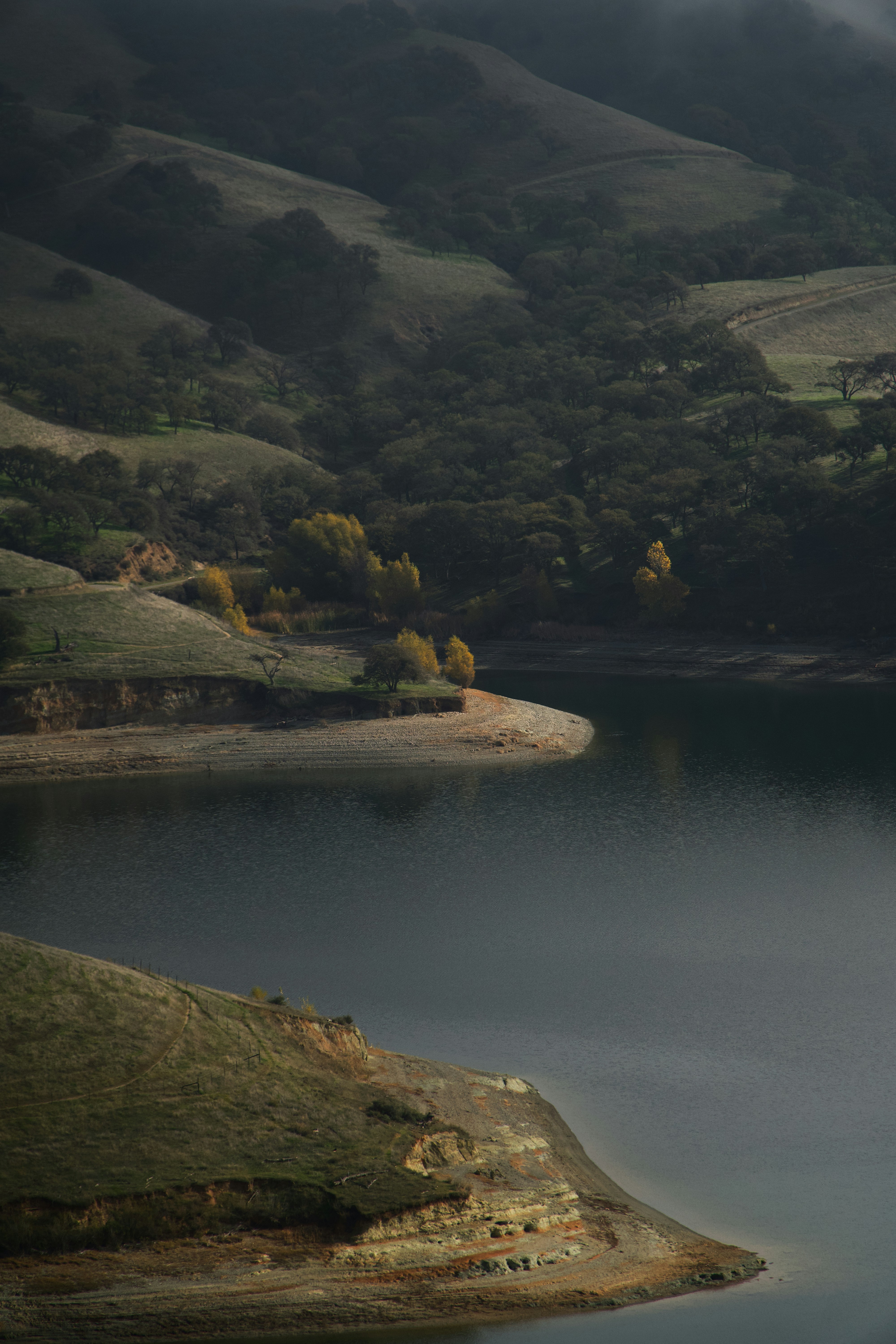 Misty hills meet a dark, still lake