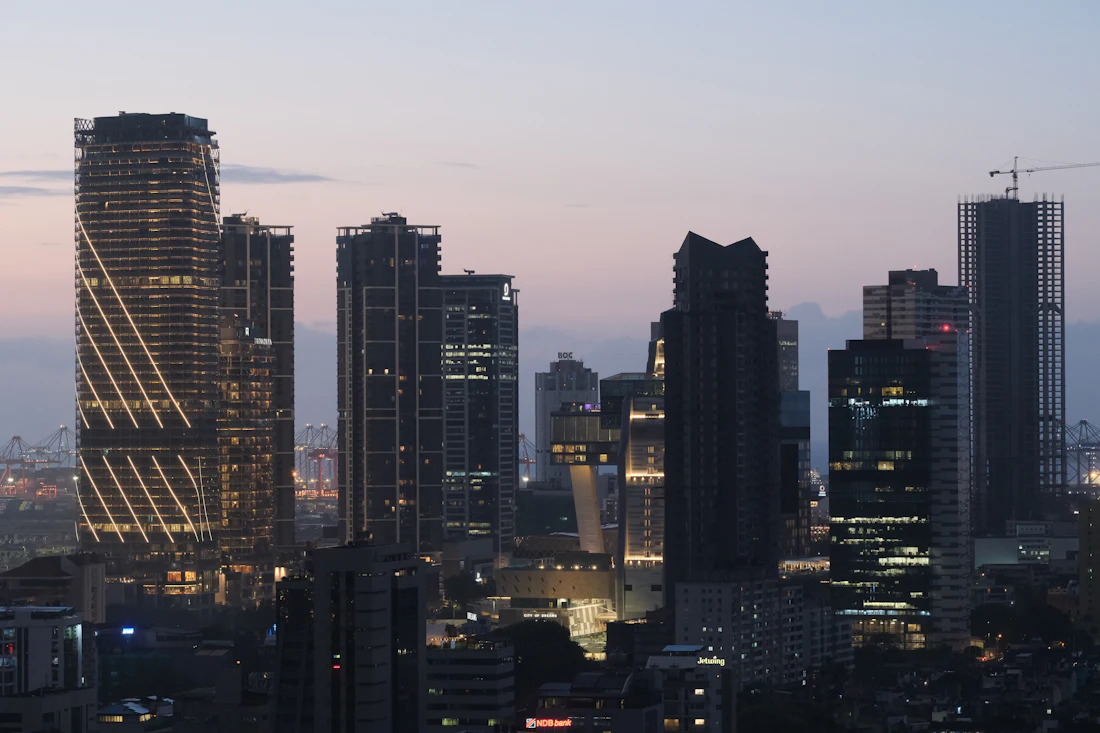 Corporate towers illuminated against a dusk sky.