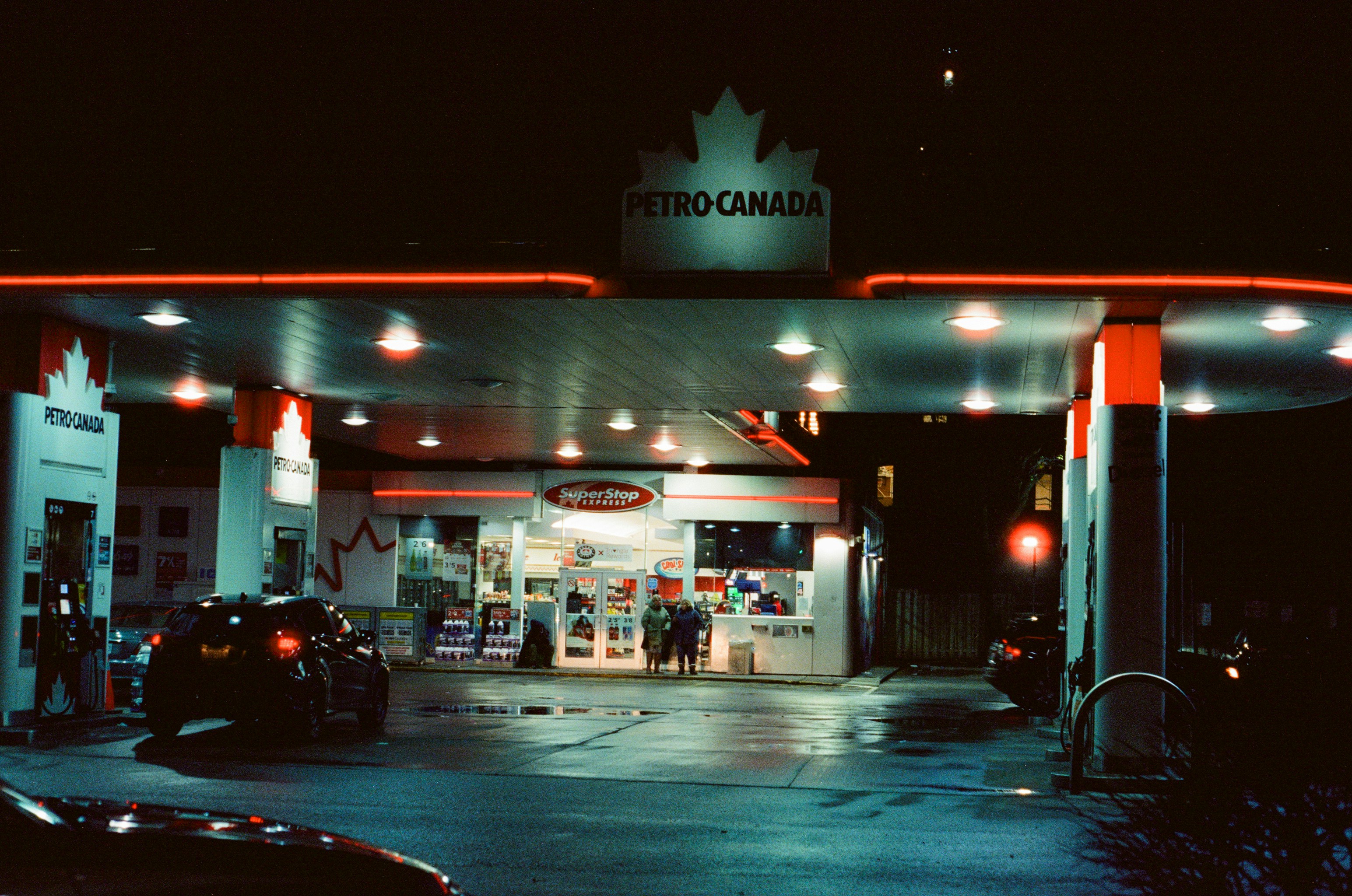 Petro-canada gas station at night with neon lights.