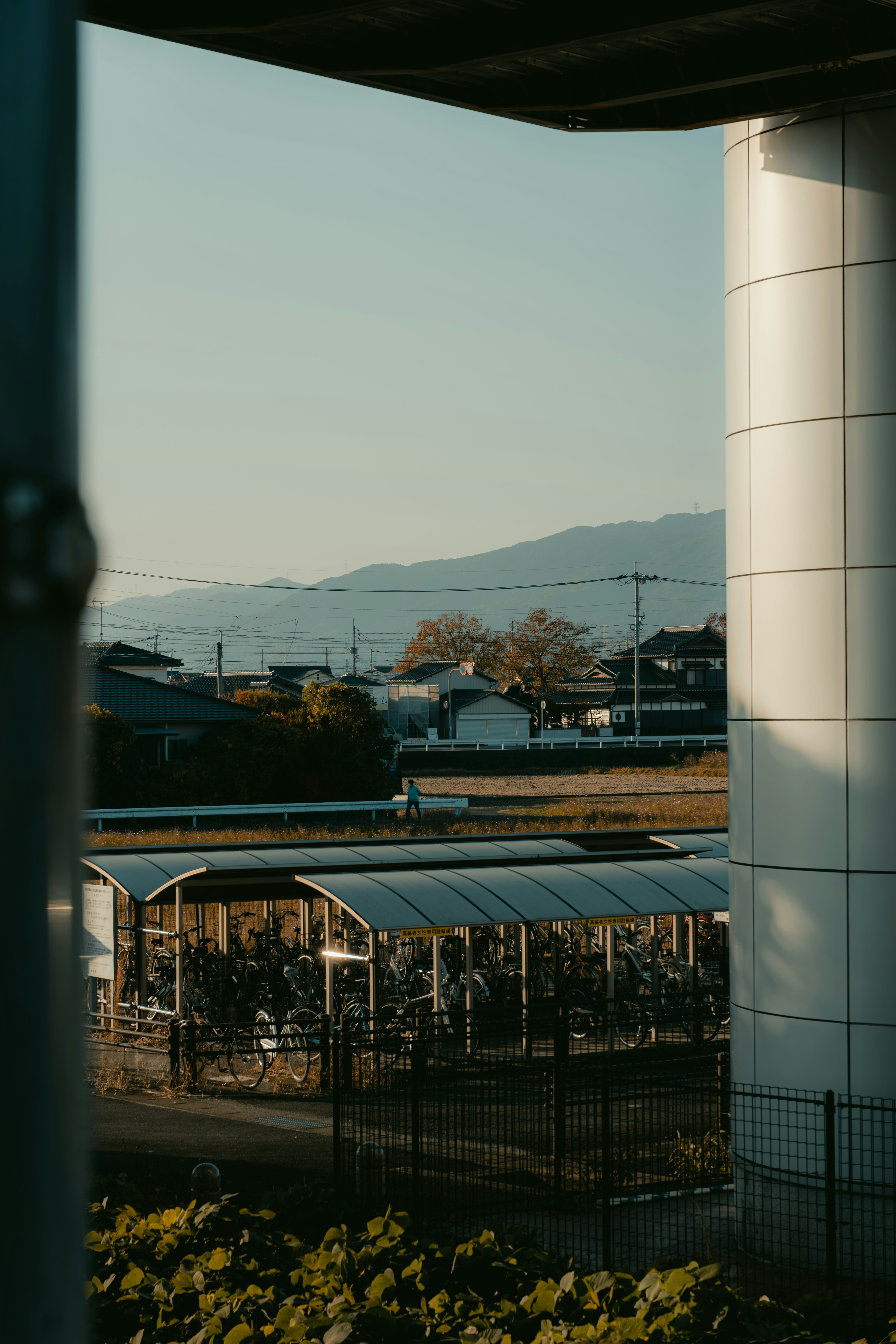 Bicicletas estacionadas sob abrigos próximos a casas e montanhas.