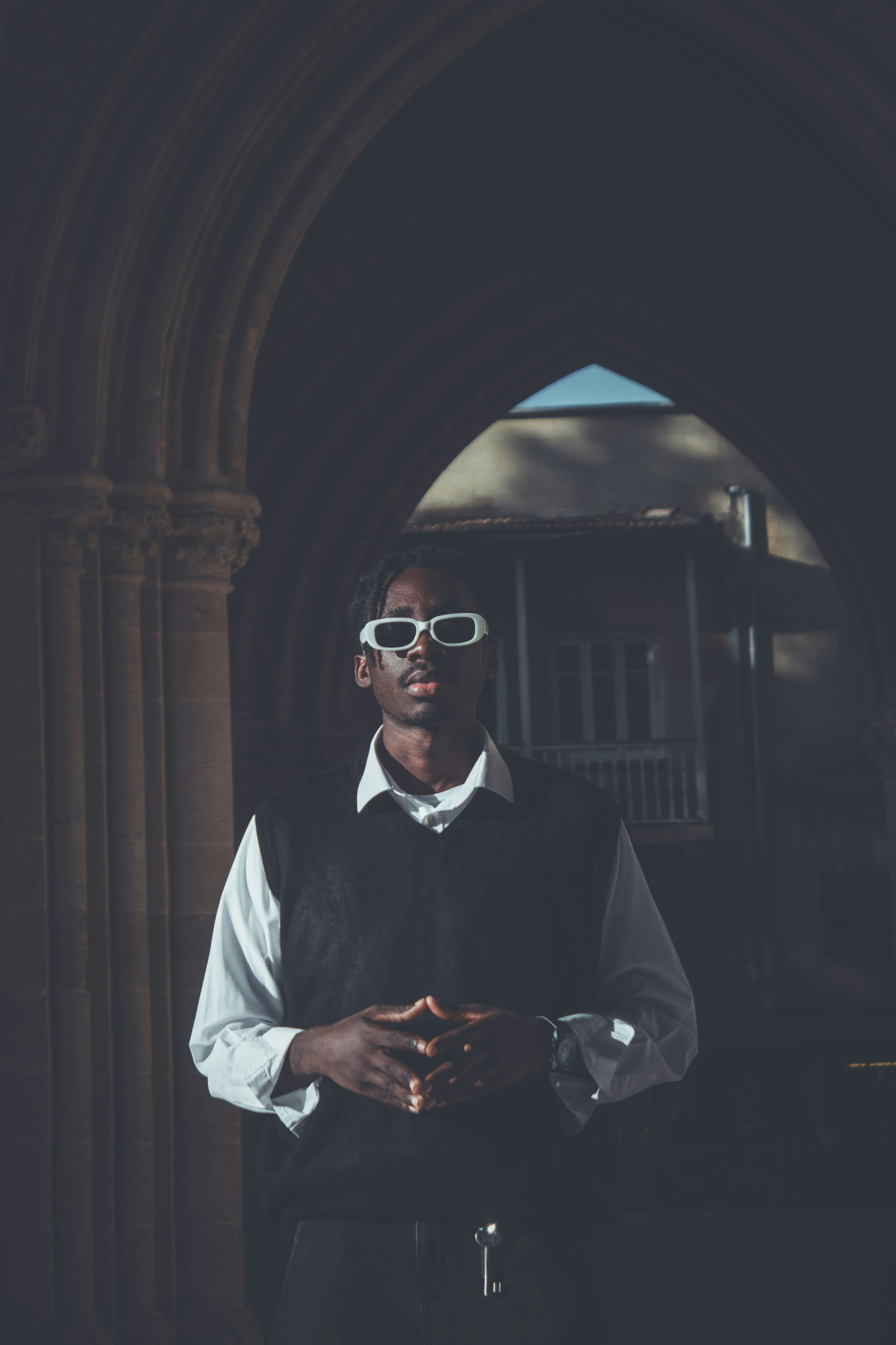 Man with sunglasses stands in arched doorway