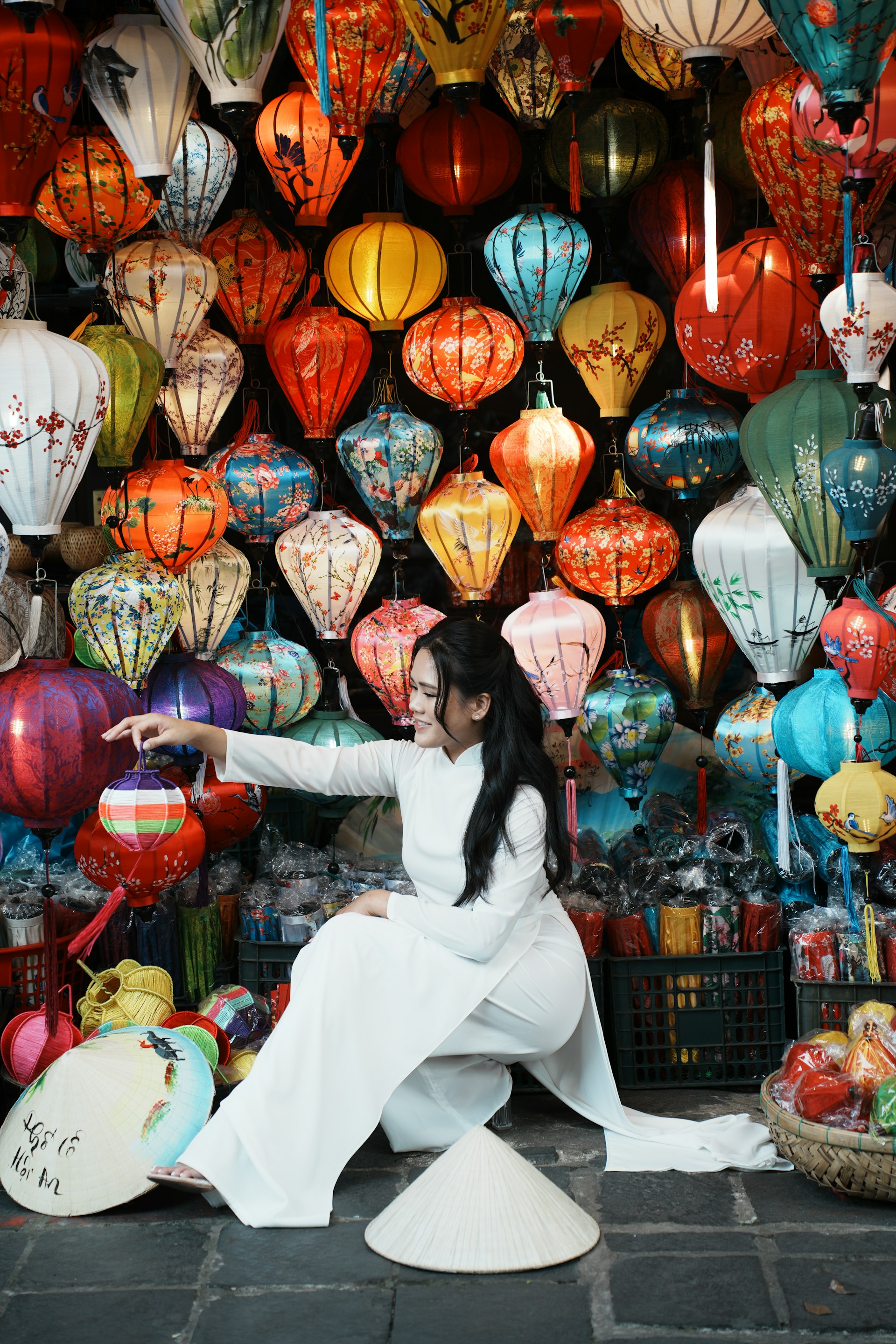 Woman in white dress surrounded by colorful lanterns