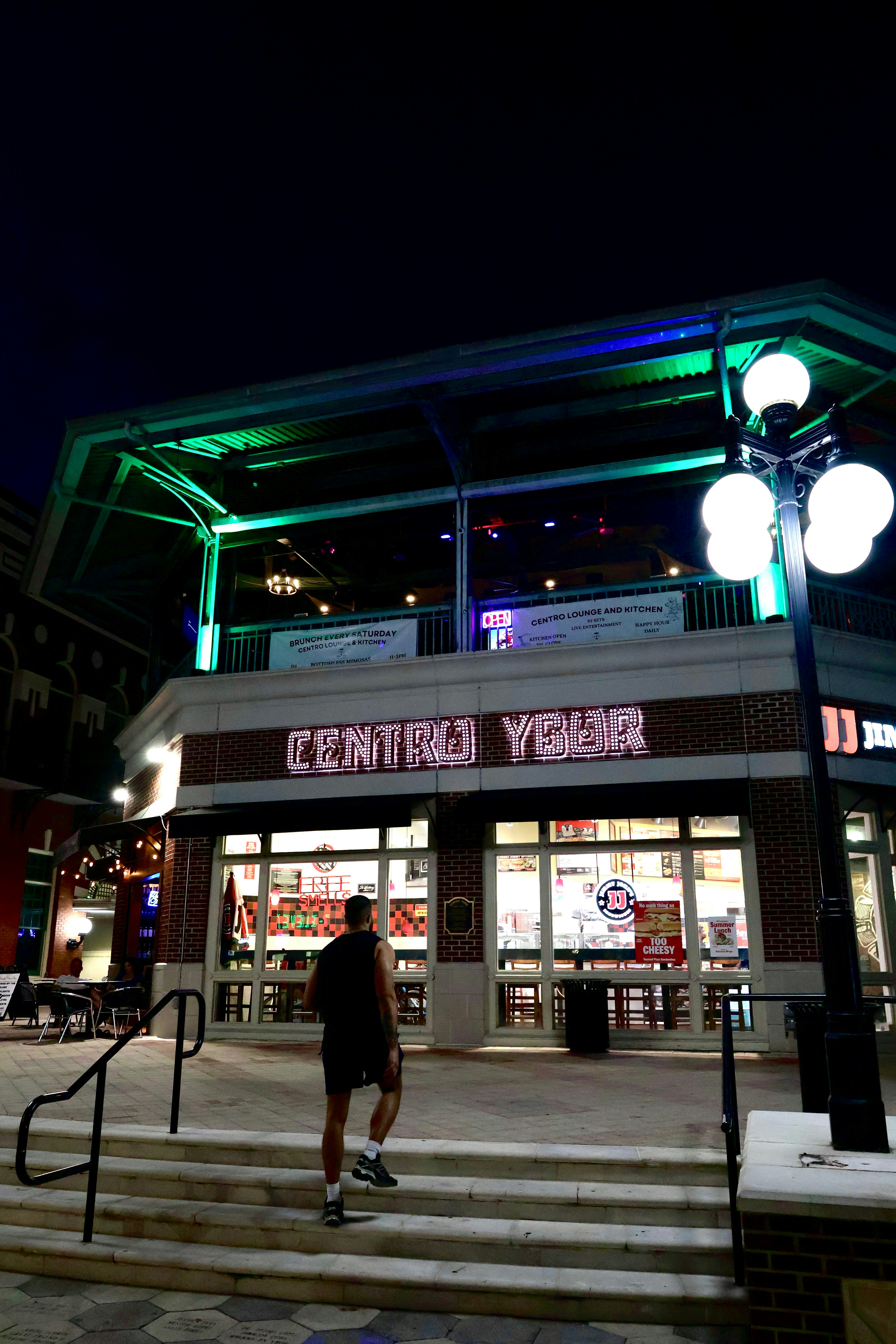 Man walks up stairs to building at night
