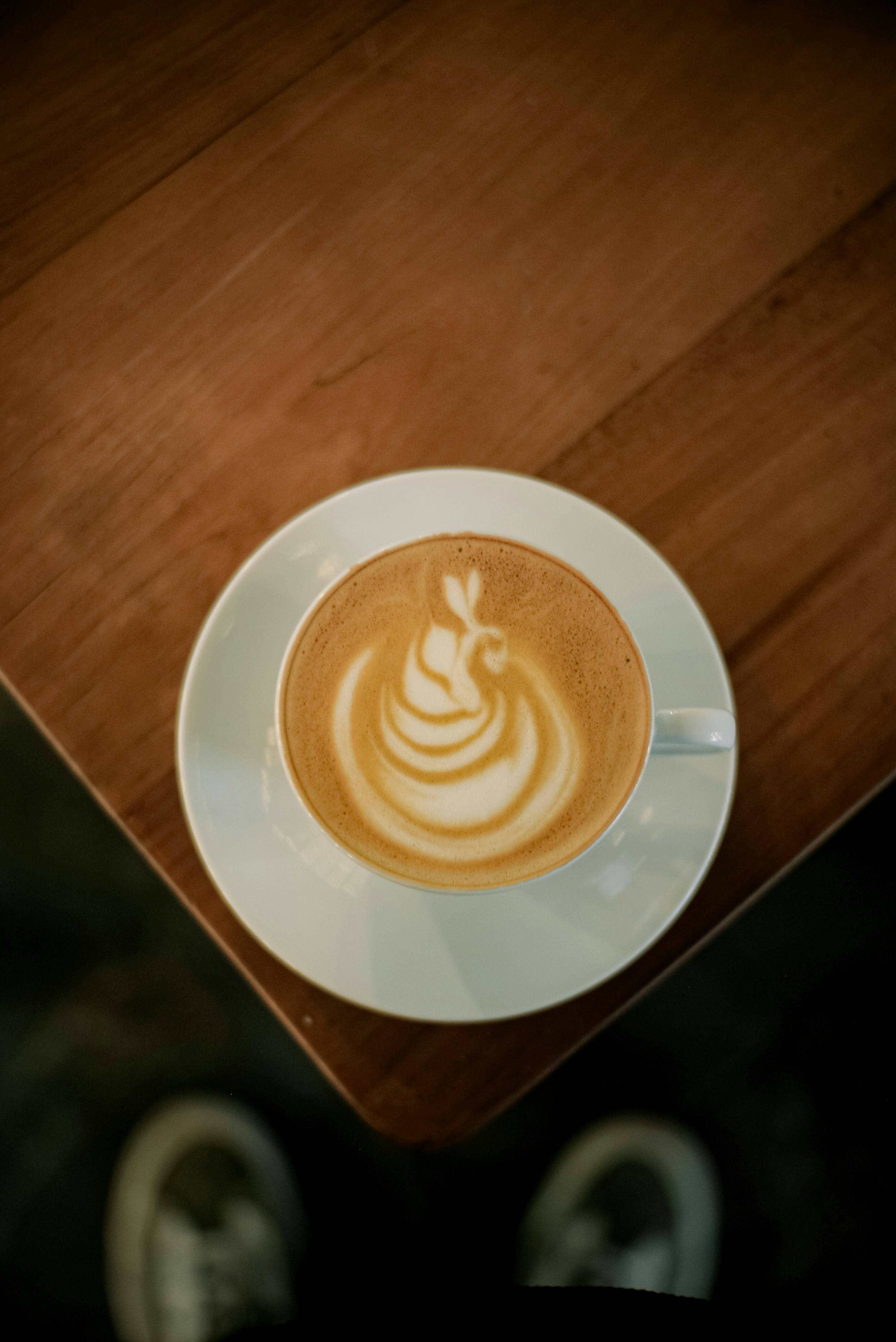 Latte art in a white cup on a wooden table