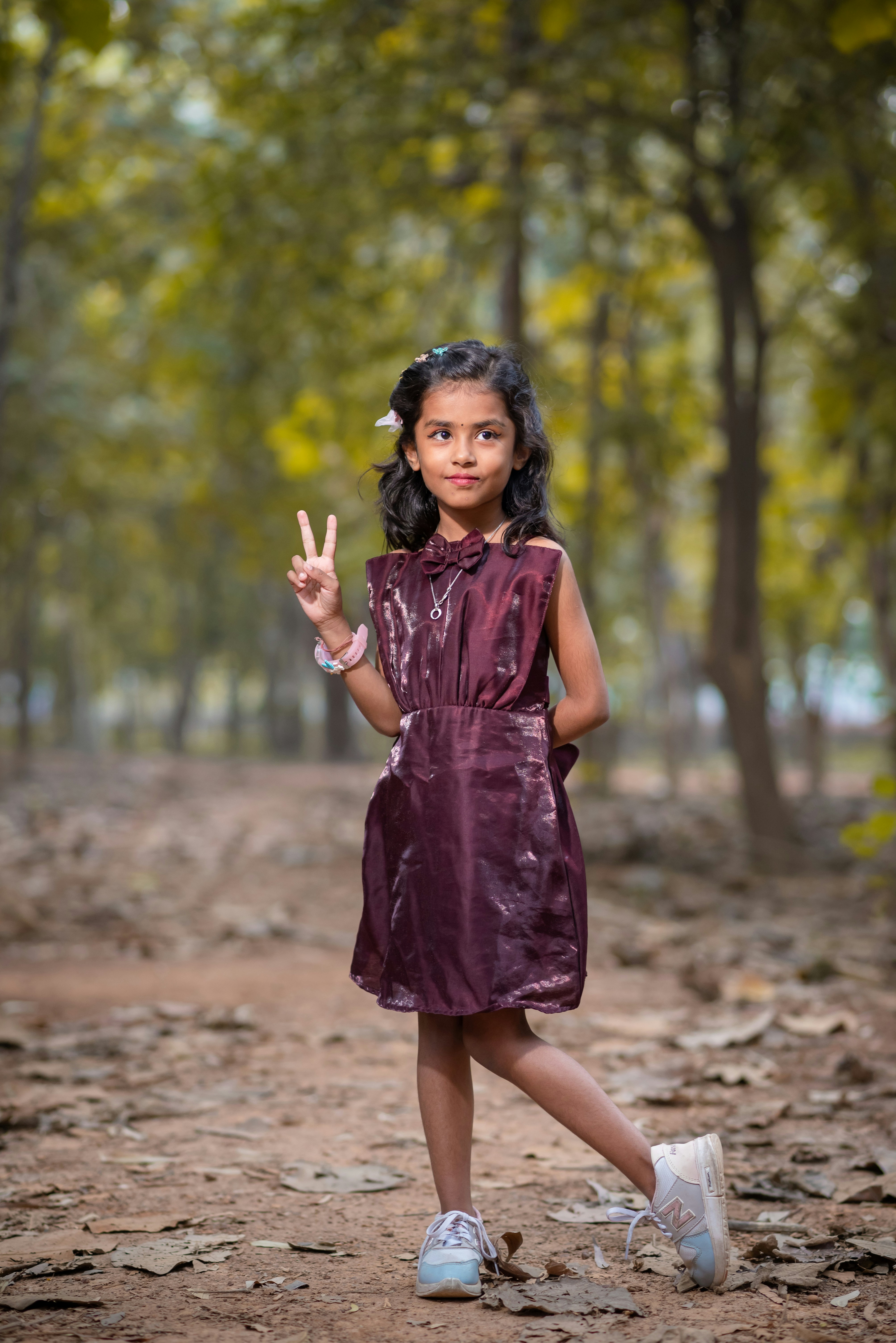 Young girl in dress poses with peace sign