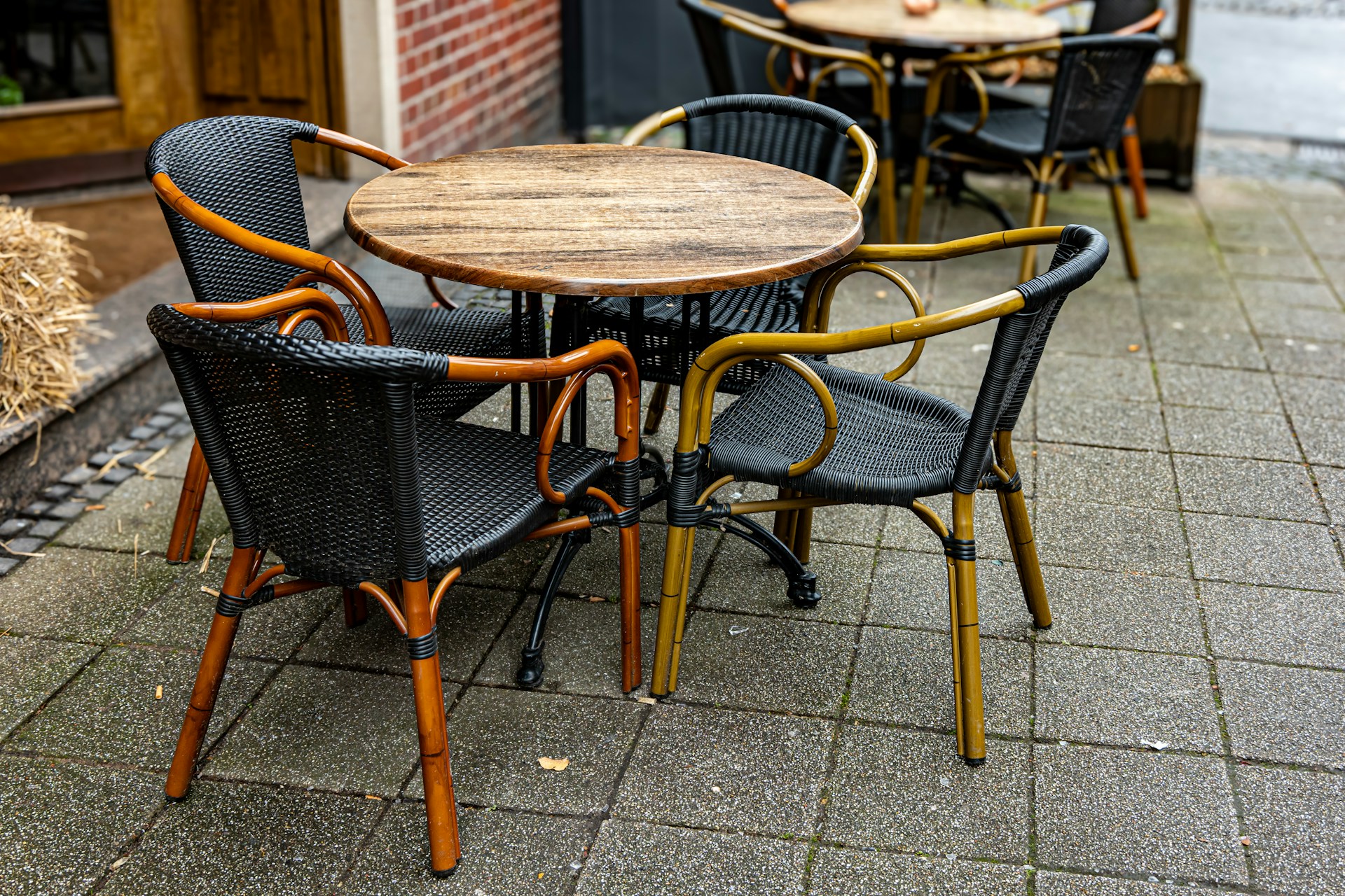 Outdoor cafe table with four chairs on cobblestone patio