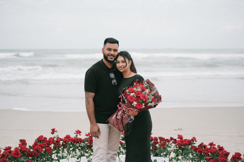 A millionaire couple posing with roses on a luxurious beach