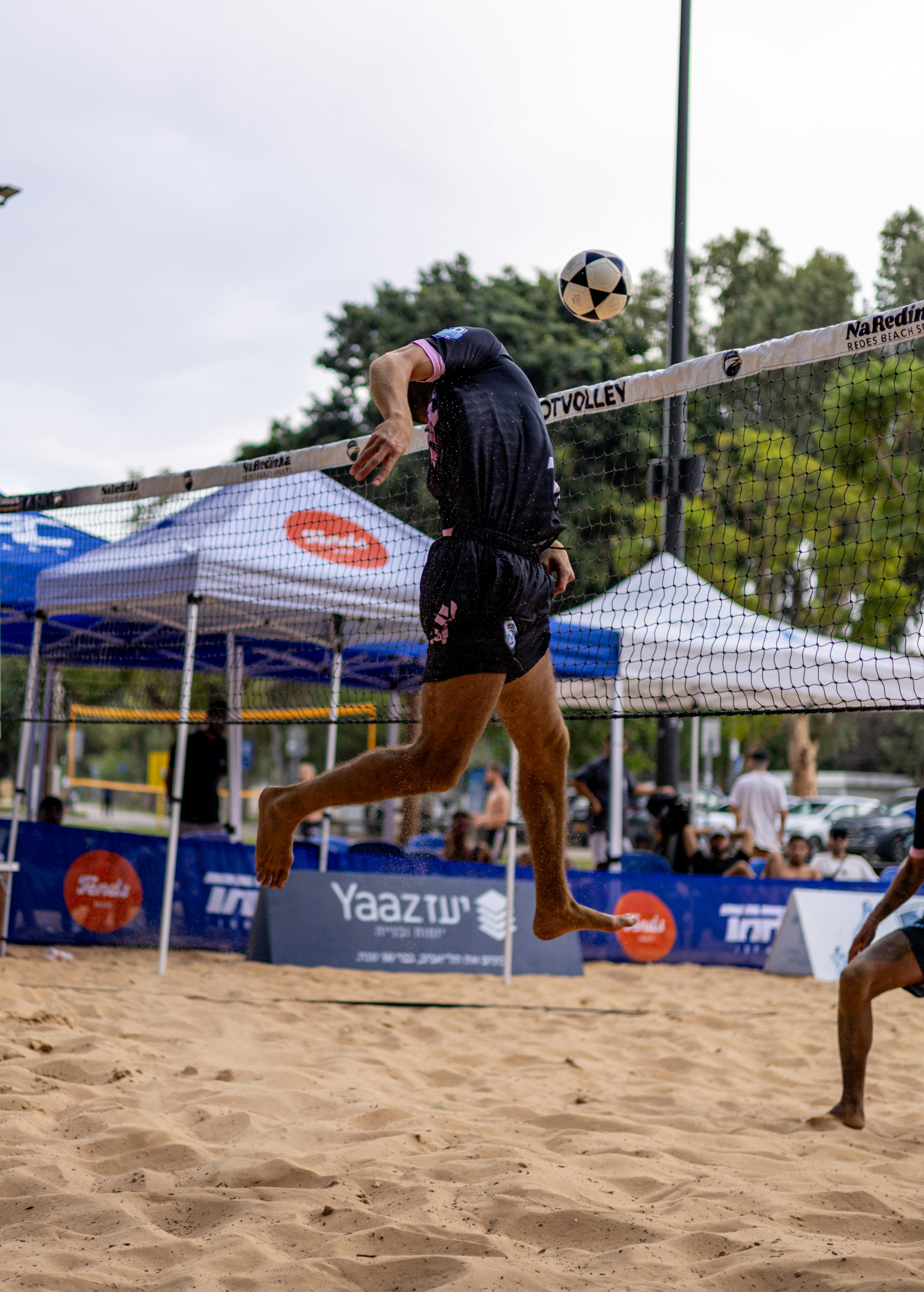 L'atleta salta di testa il pallone da calcio sopra la porta