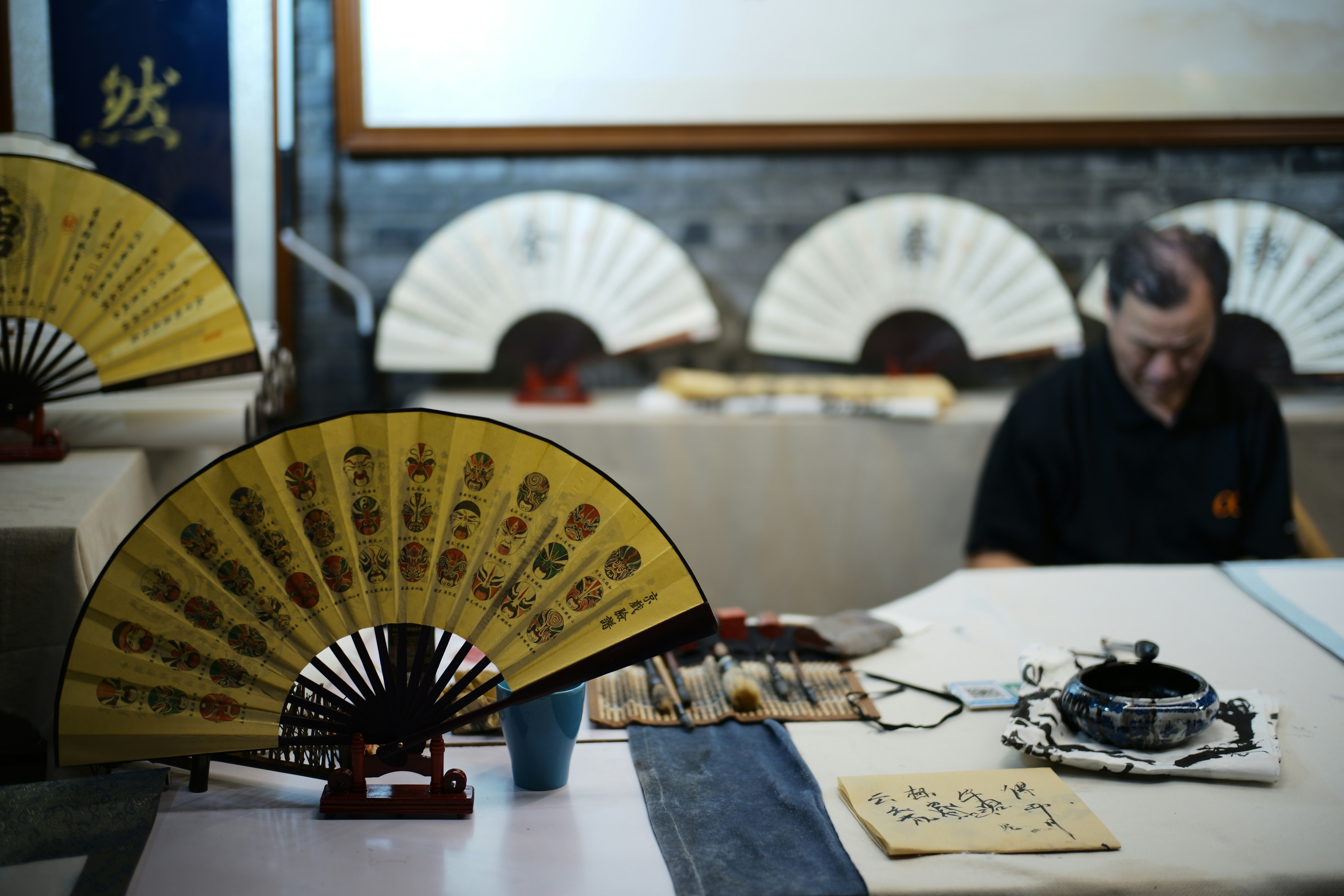 Man sitting at a table with traditional fans