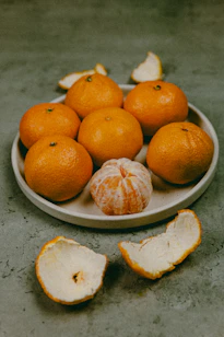 Plate of tangerines with peels on table