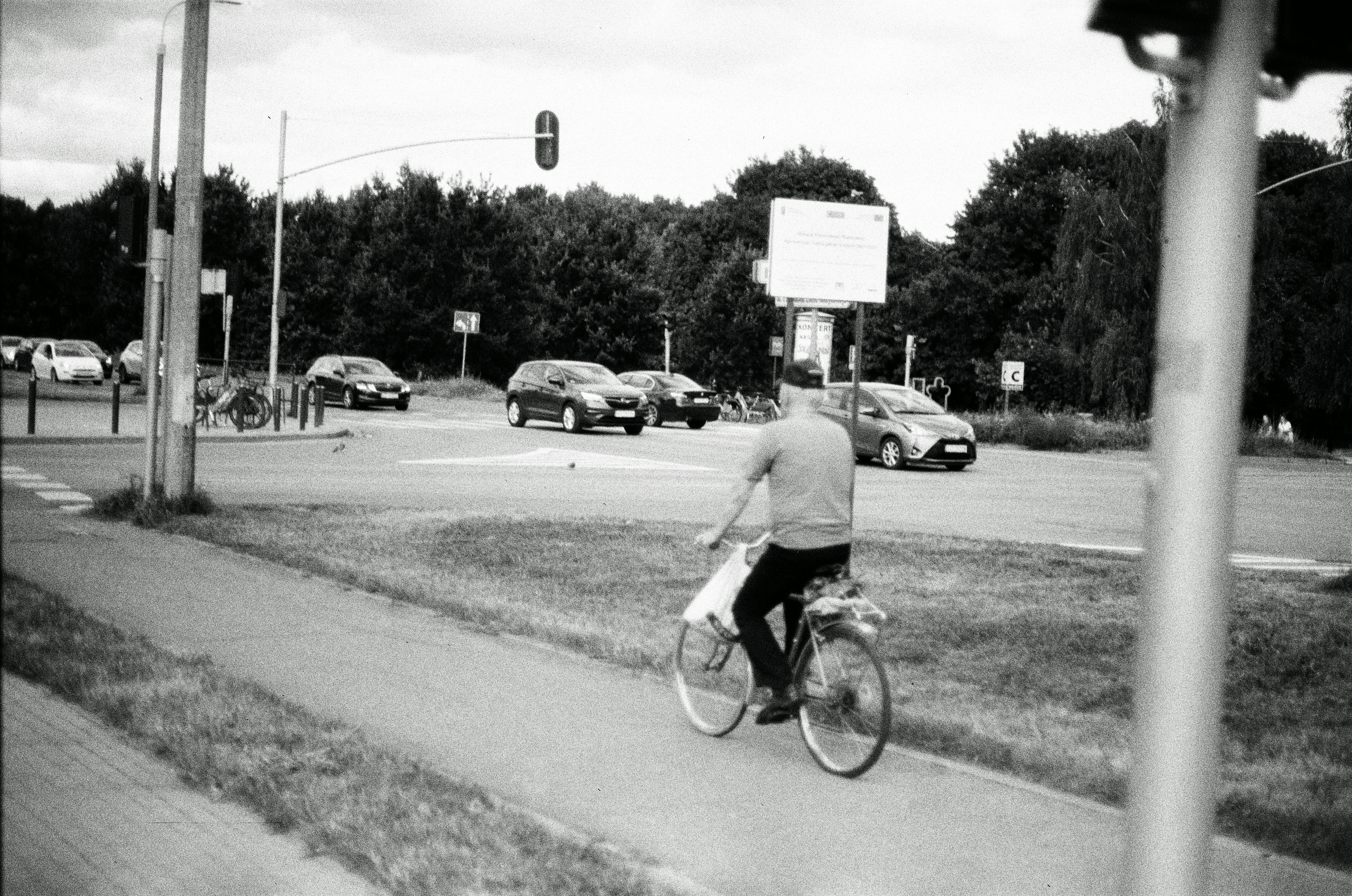 Man rides bicycle on path near road