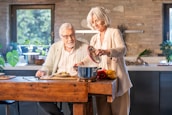 Elderly couple cooking together in a modern kitchen.