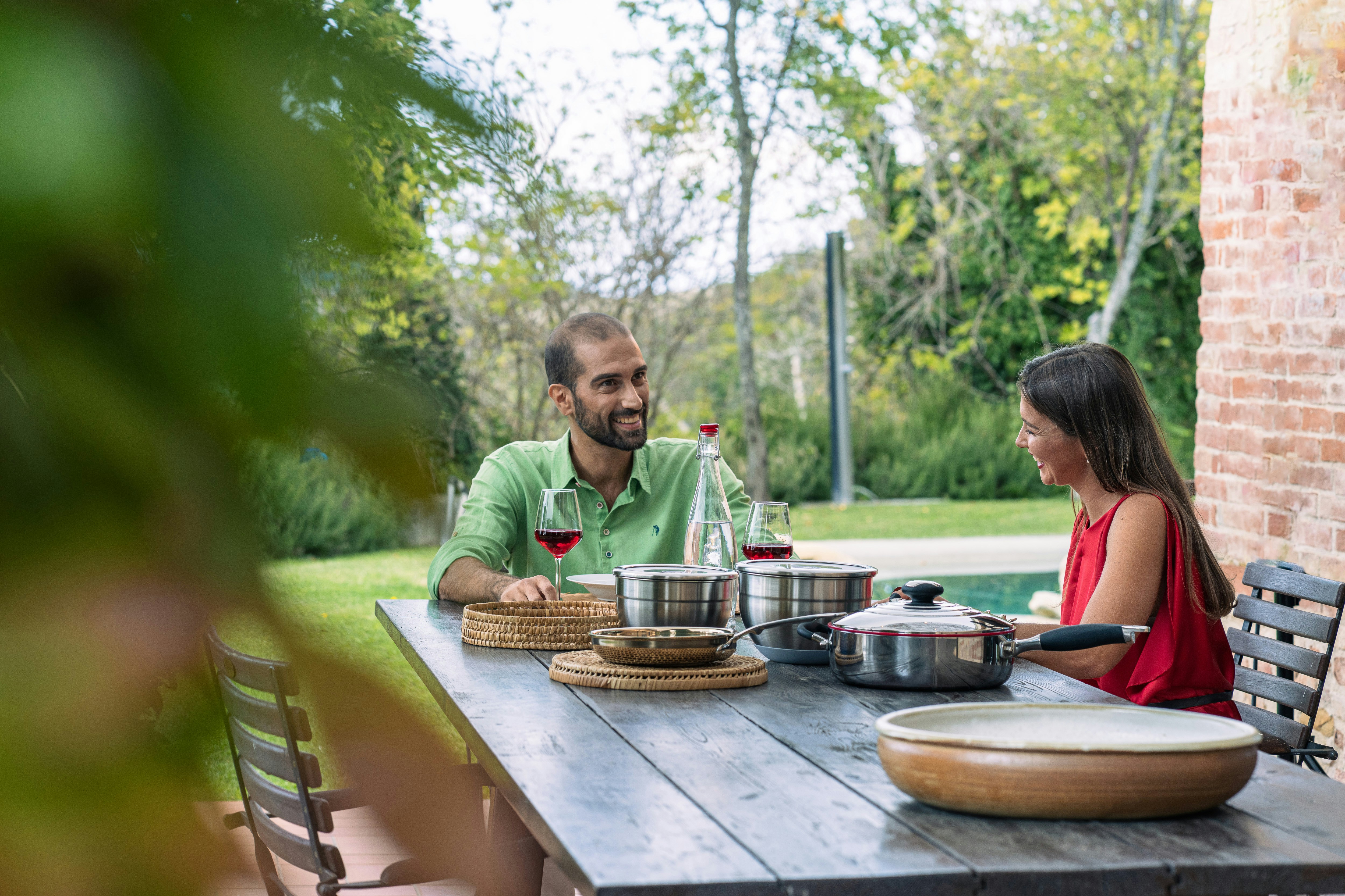 Couple enjoying a meal outdoors at a table.