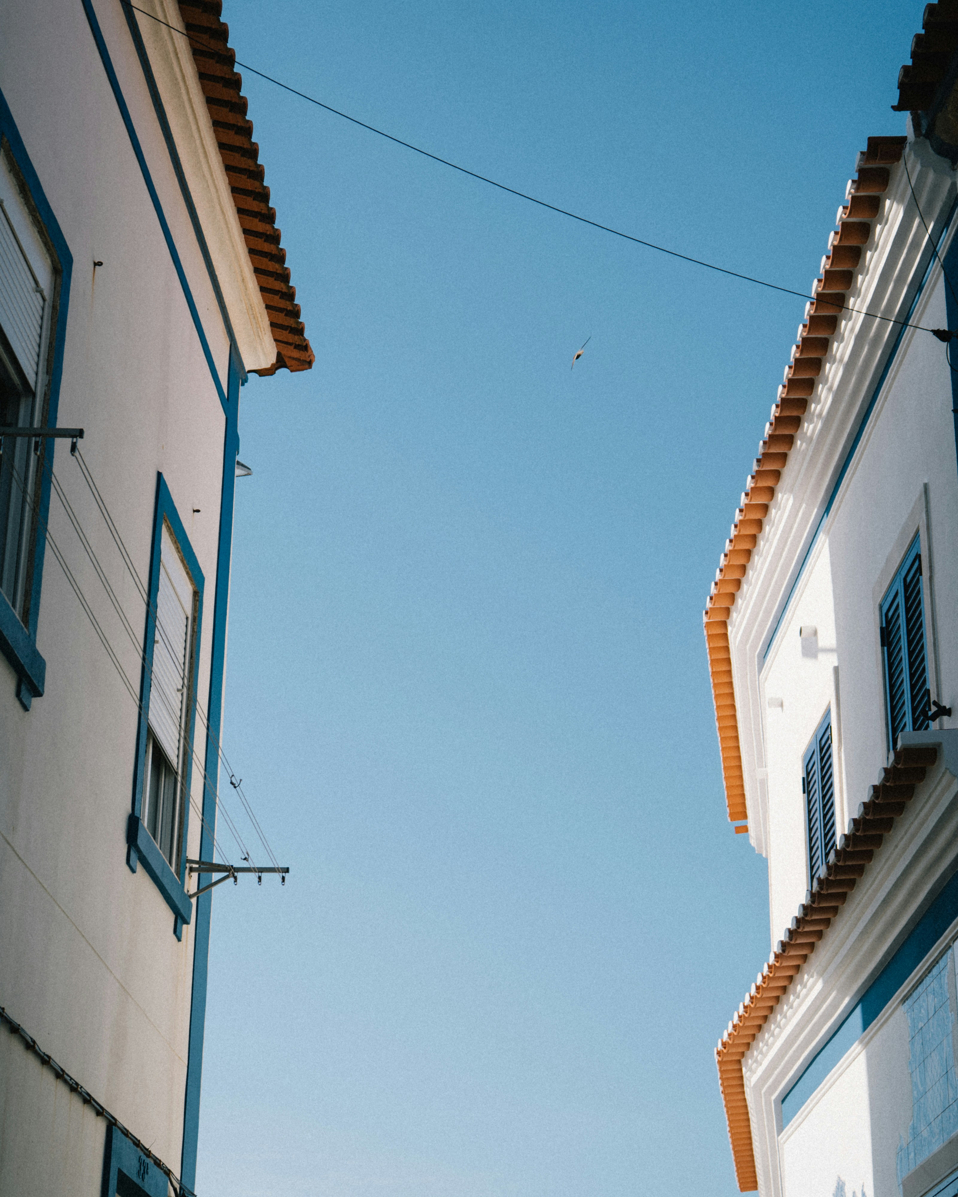 Two white buildings against a clear blue sky