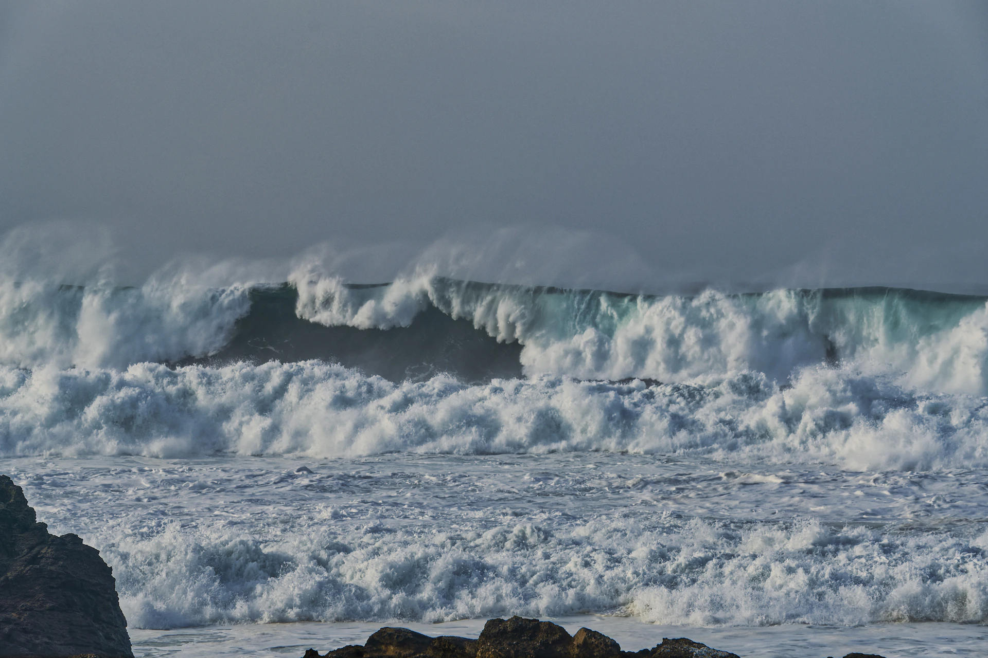 Crashing ocean waves under a cloudy sky