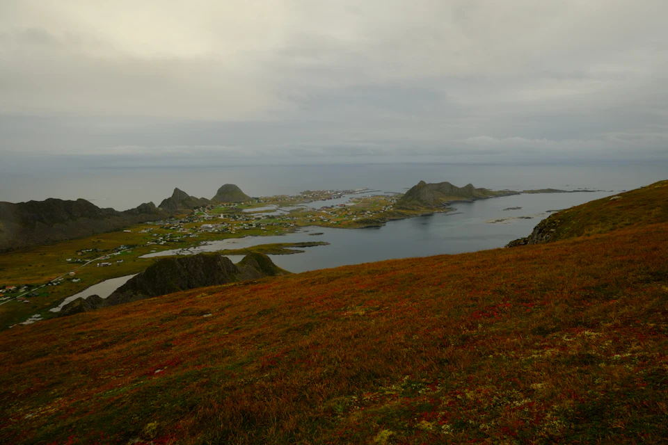 Serene coastal landscape with small town on hillside overlooking large body of water below