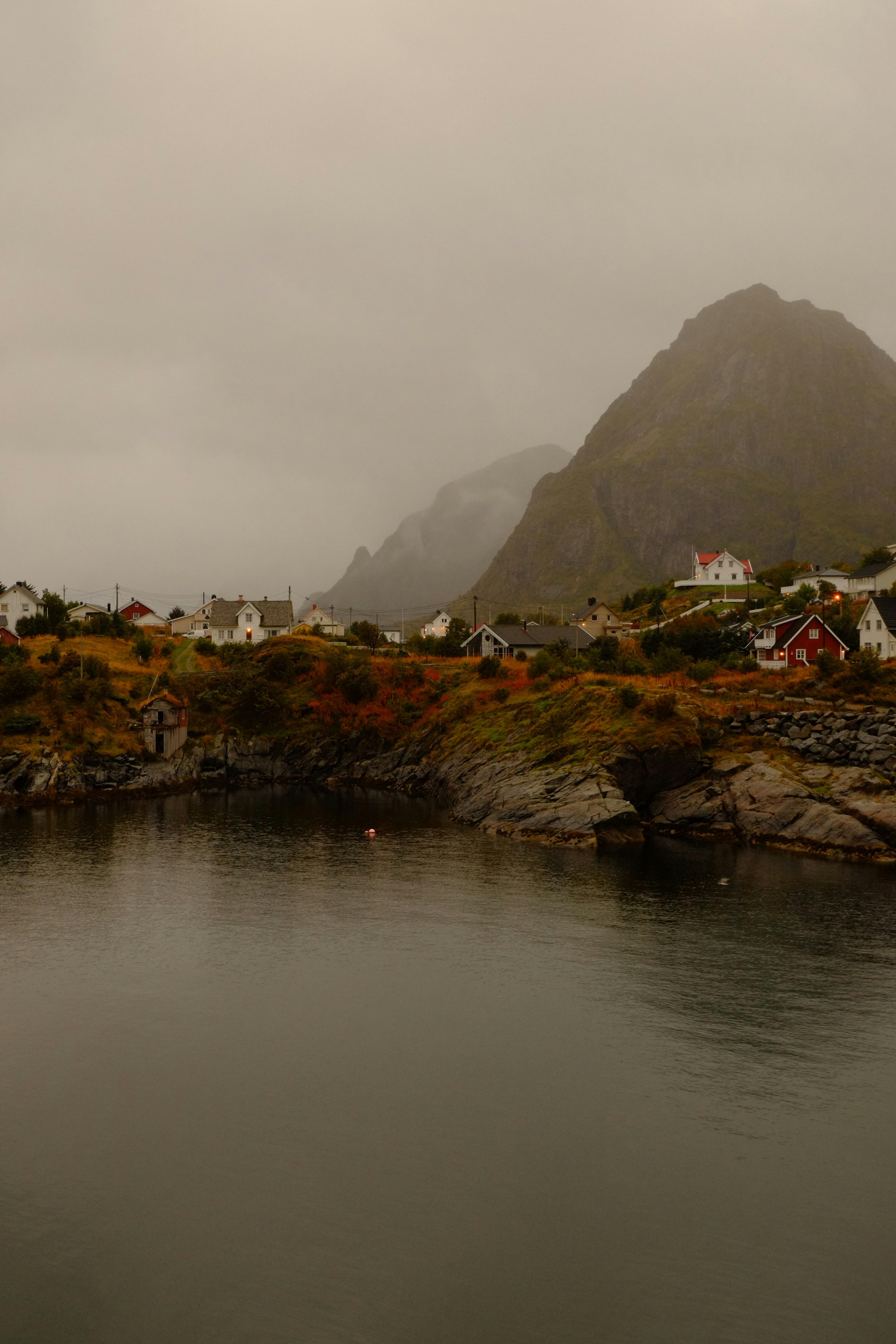 Coastal village nestled below misty mountains