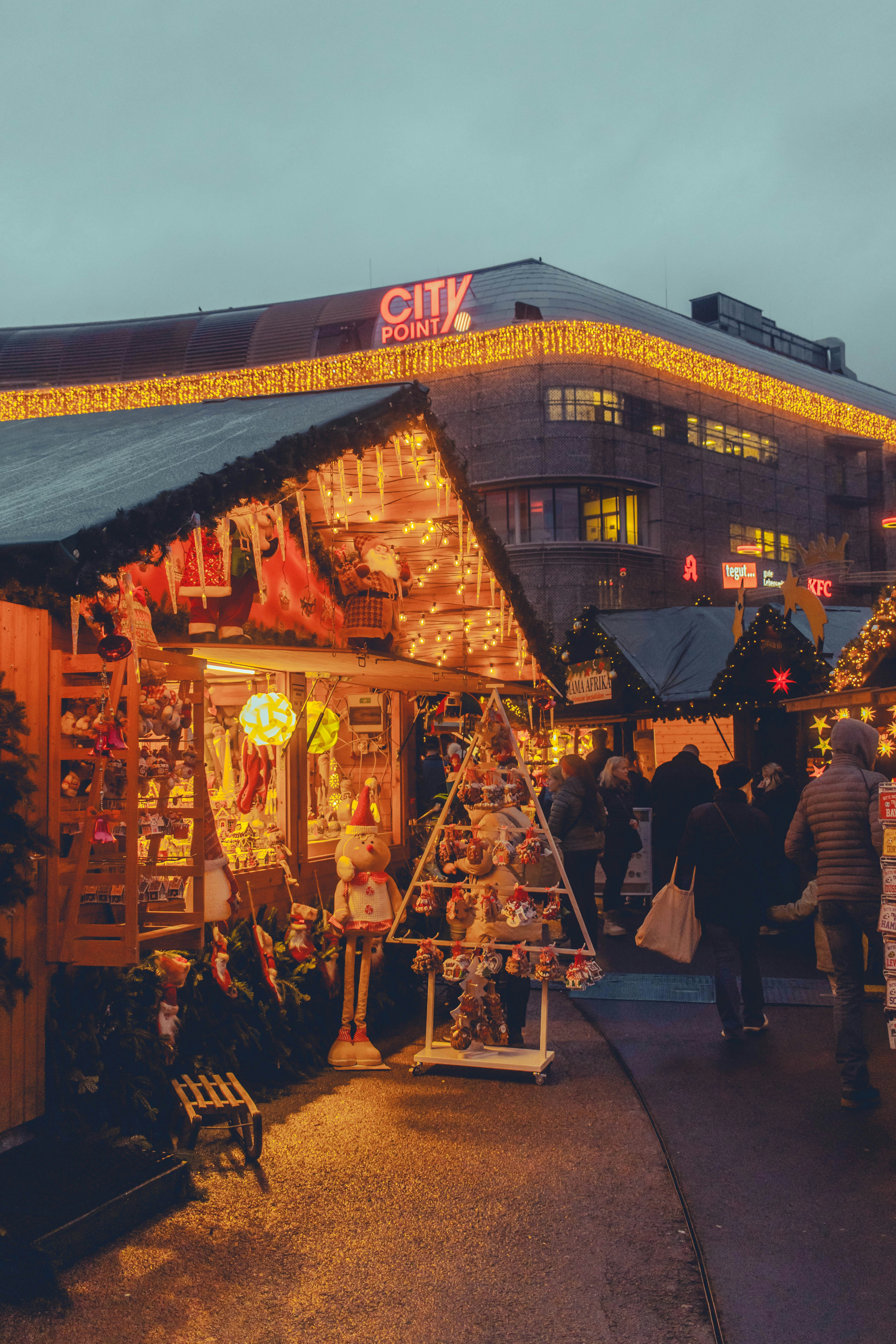 Christmas market stalls with festive lights at dusk