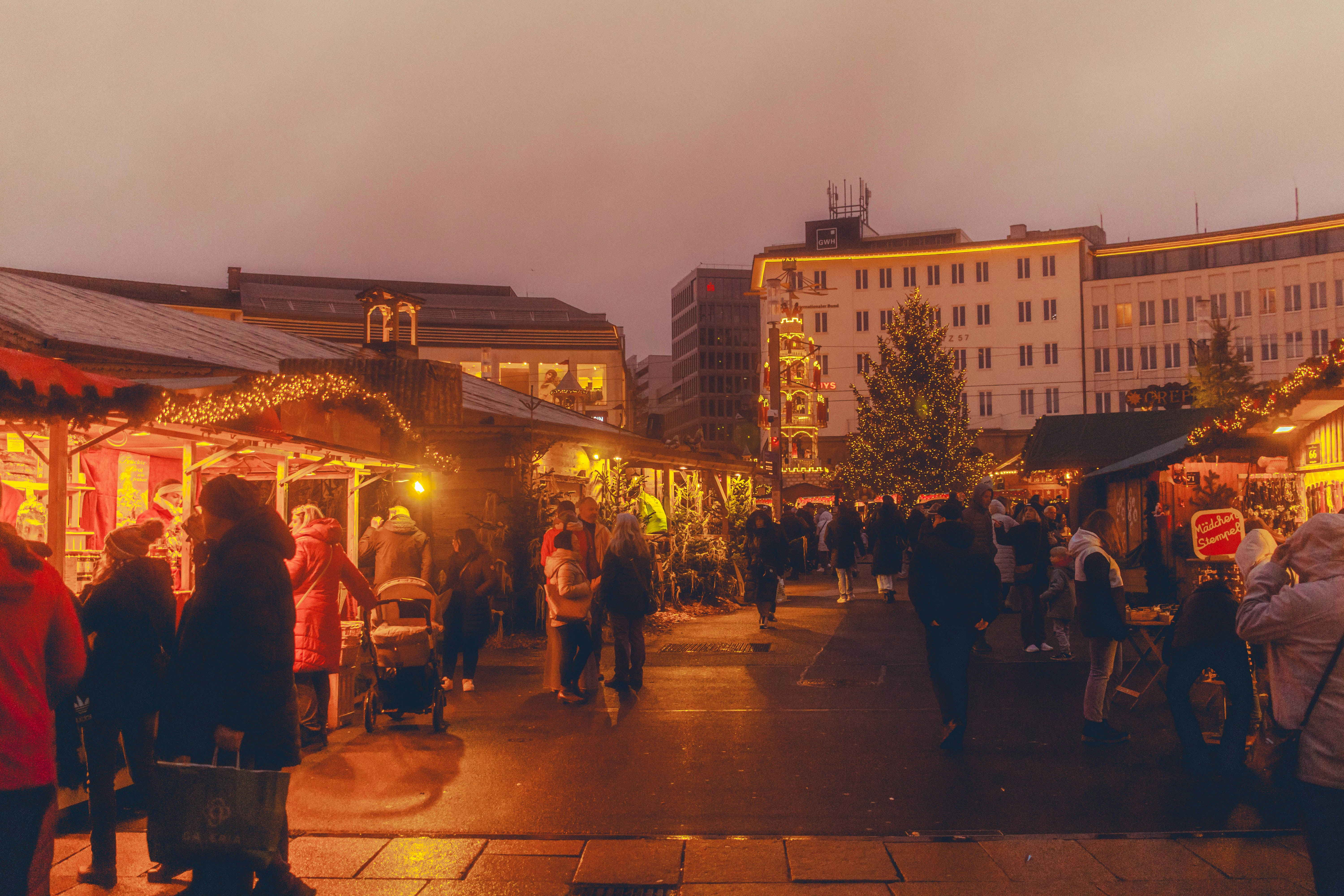Menschen, die bei Einbruch der Dämmerung durch einen festlichen Freiluftmarkt gehen