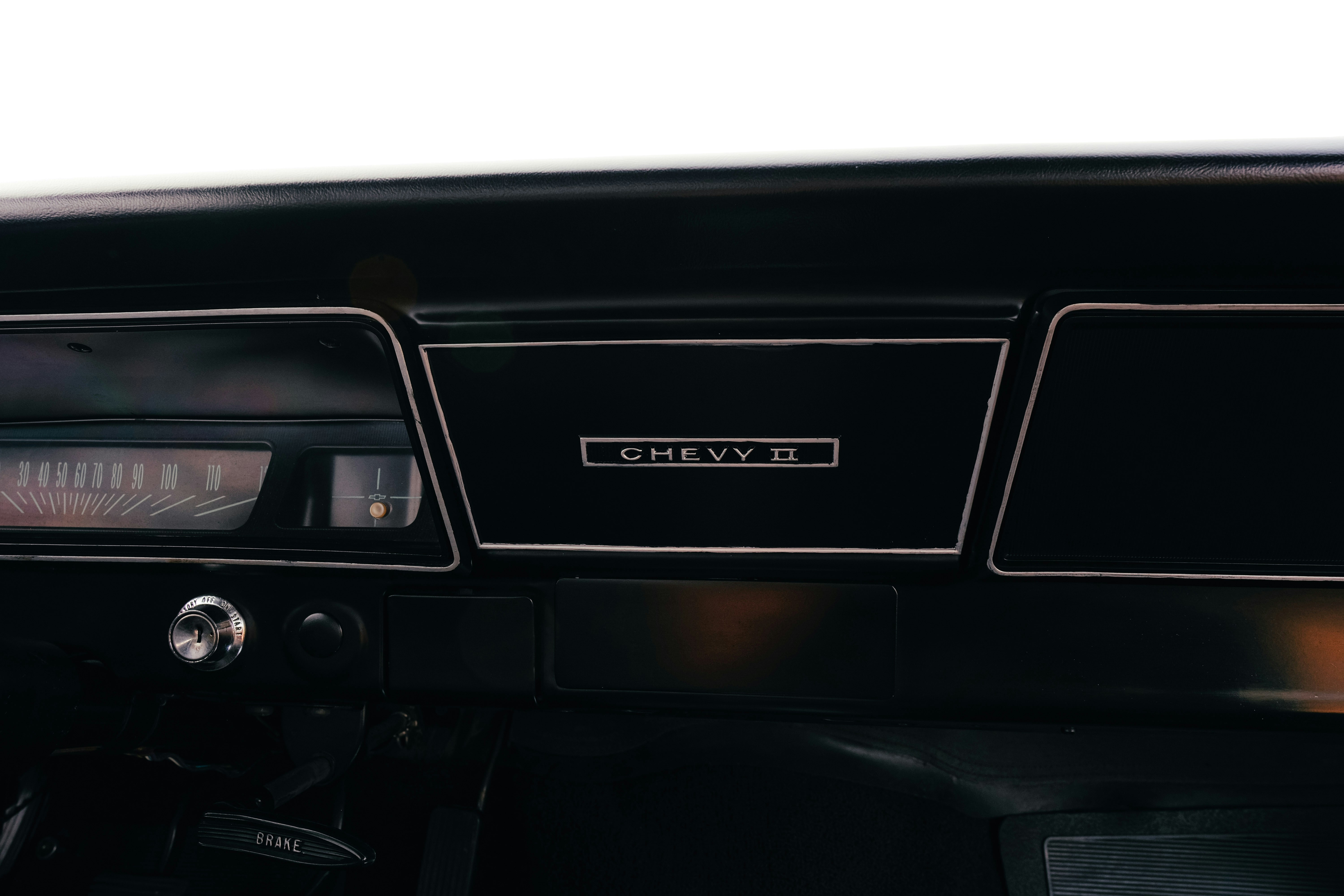 Close-up of a vintage car's dashboard with 'chevy' emblem.