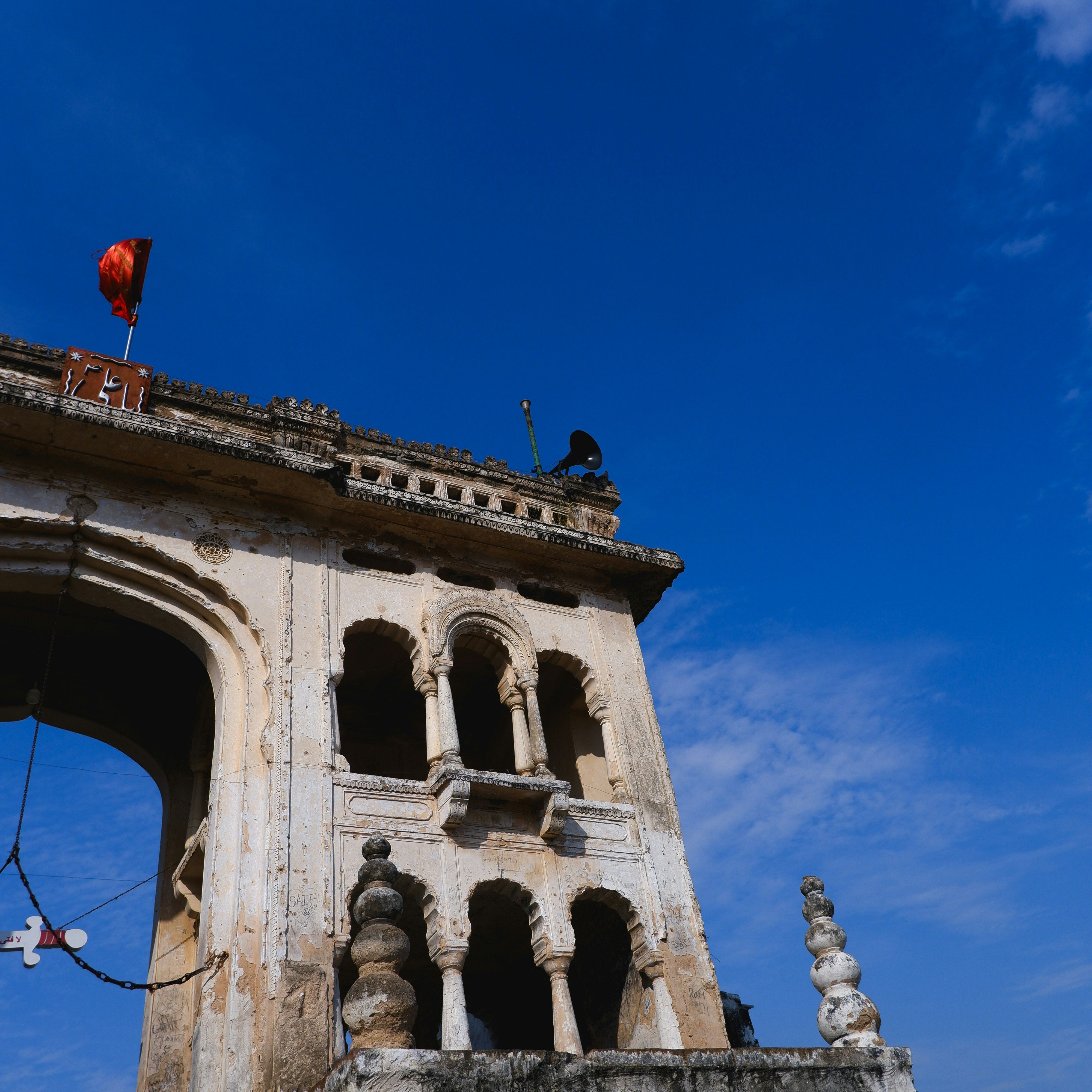 Ancient stone archway with ornate carvings under blue sky