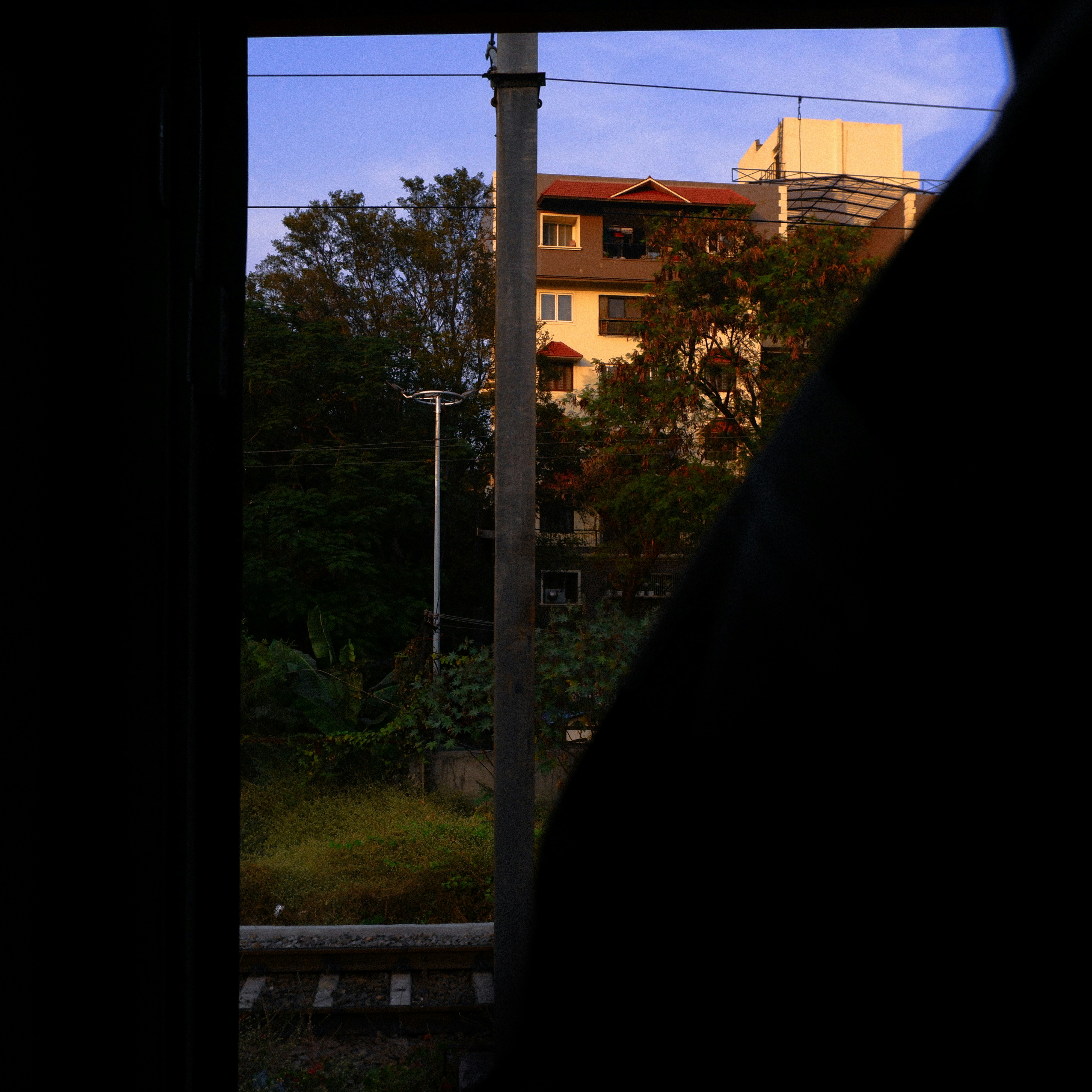 Buildings and trees seen through a dark frame.