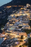 Coastal town illuminated at dusk with boats on the beach.