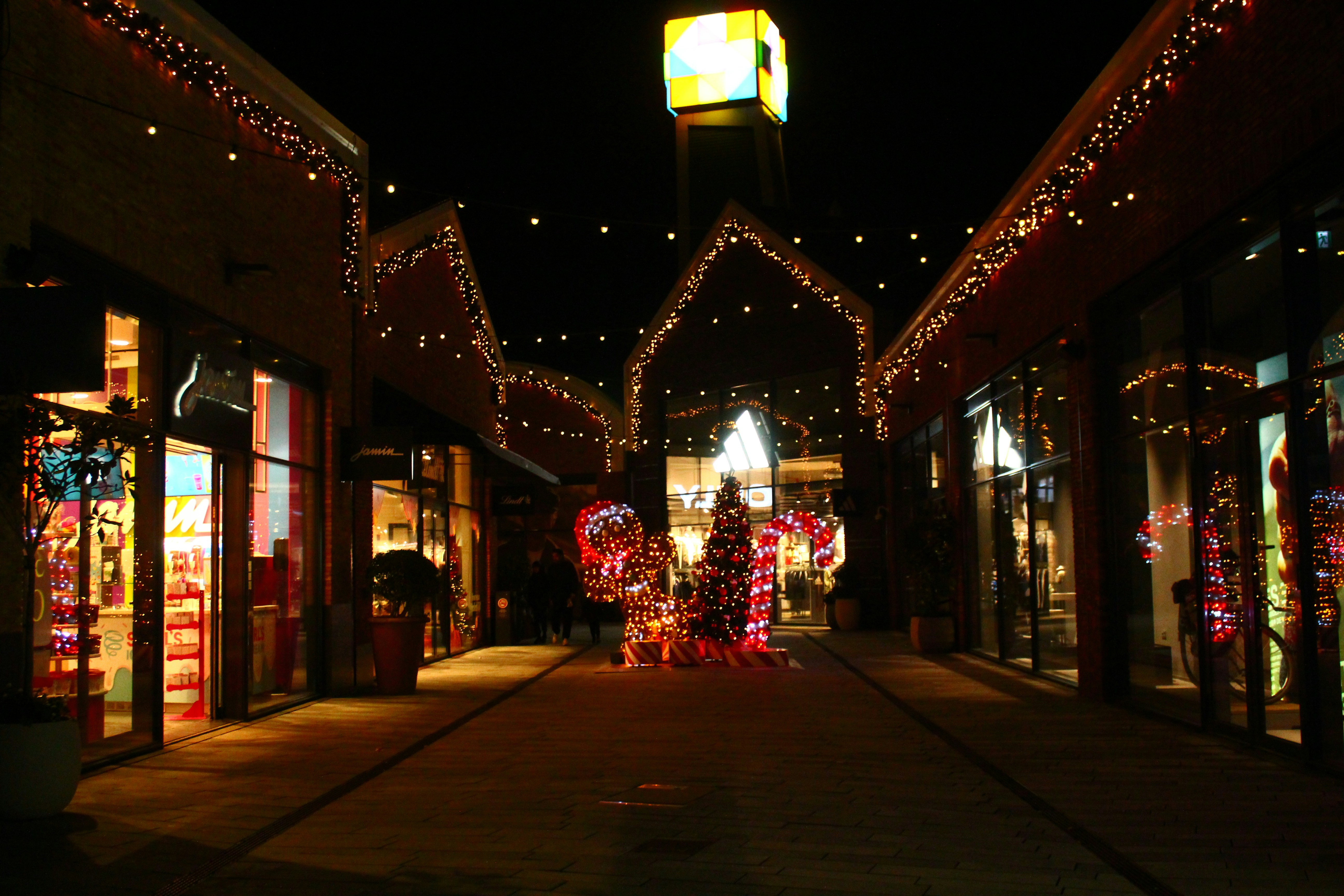 Shops decorated with christmas lights at night
