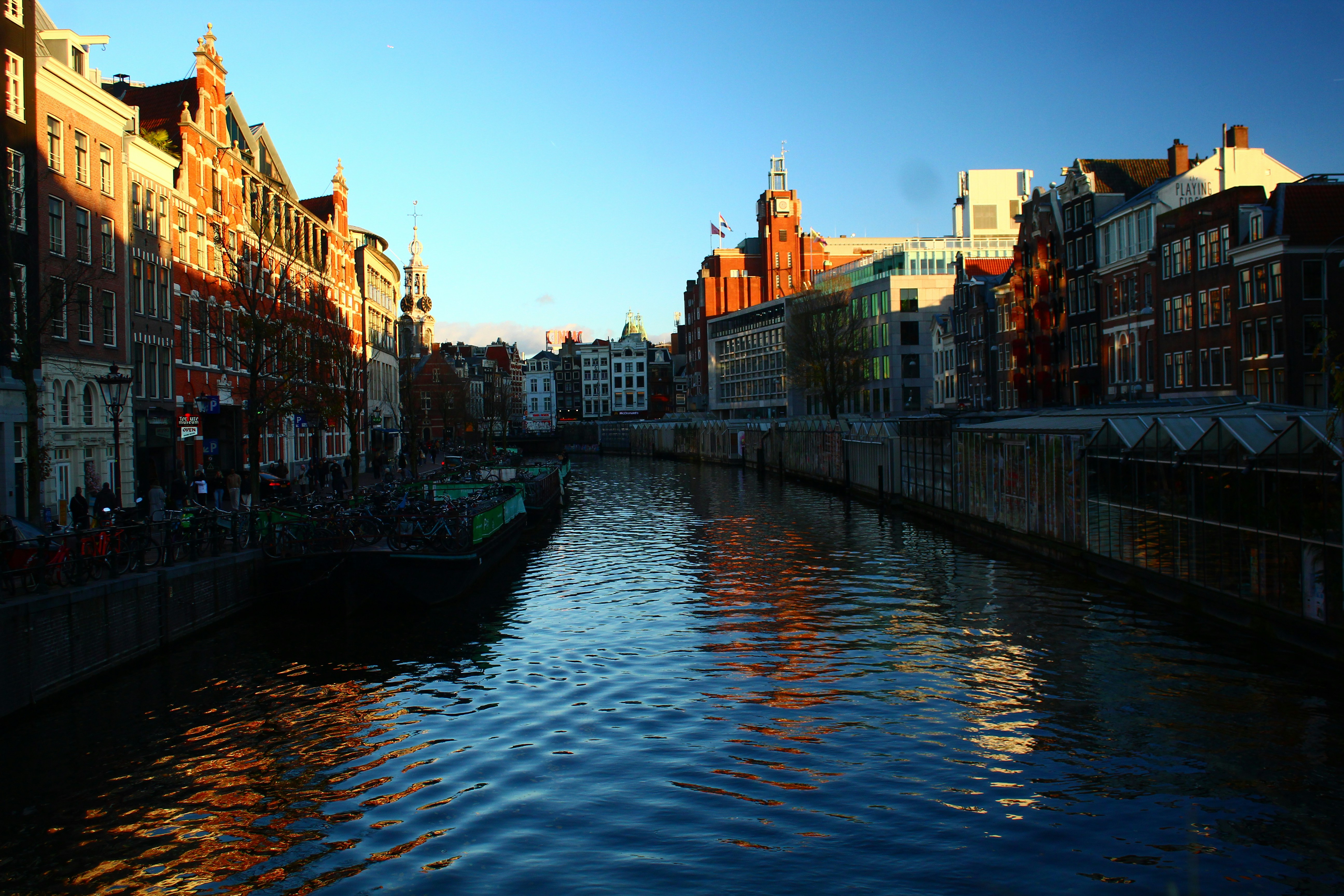 Canal with historic buildings and clear blue sky.