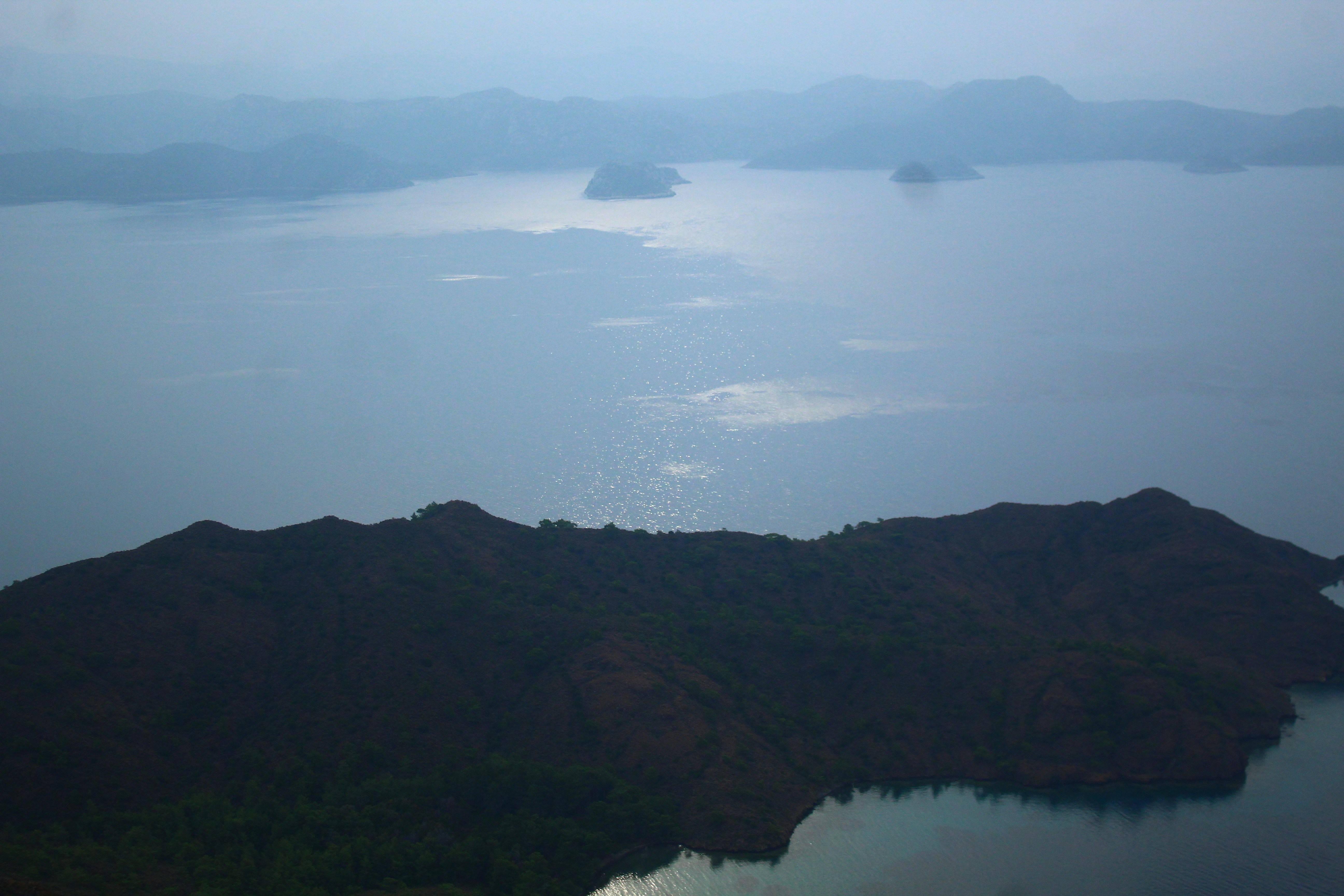 Islands in a calm, misty lake at dawn.