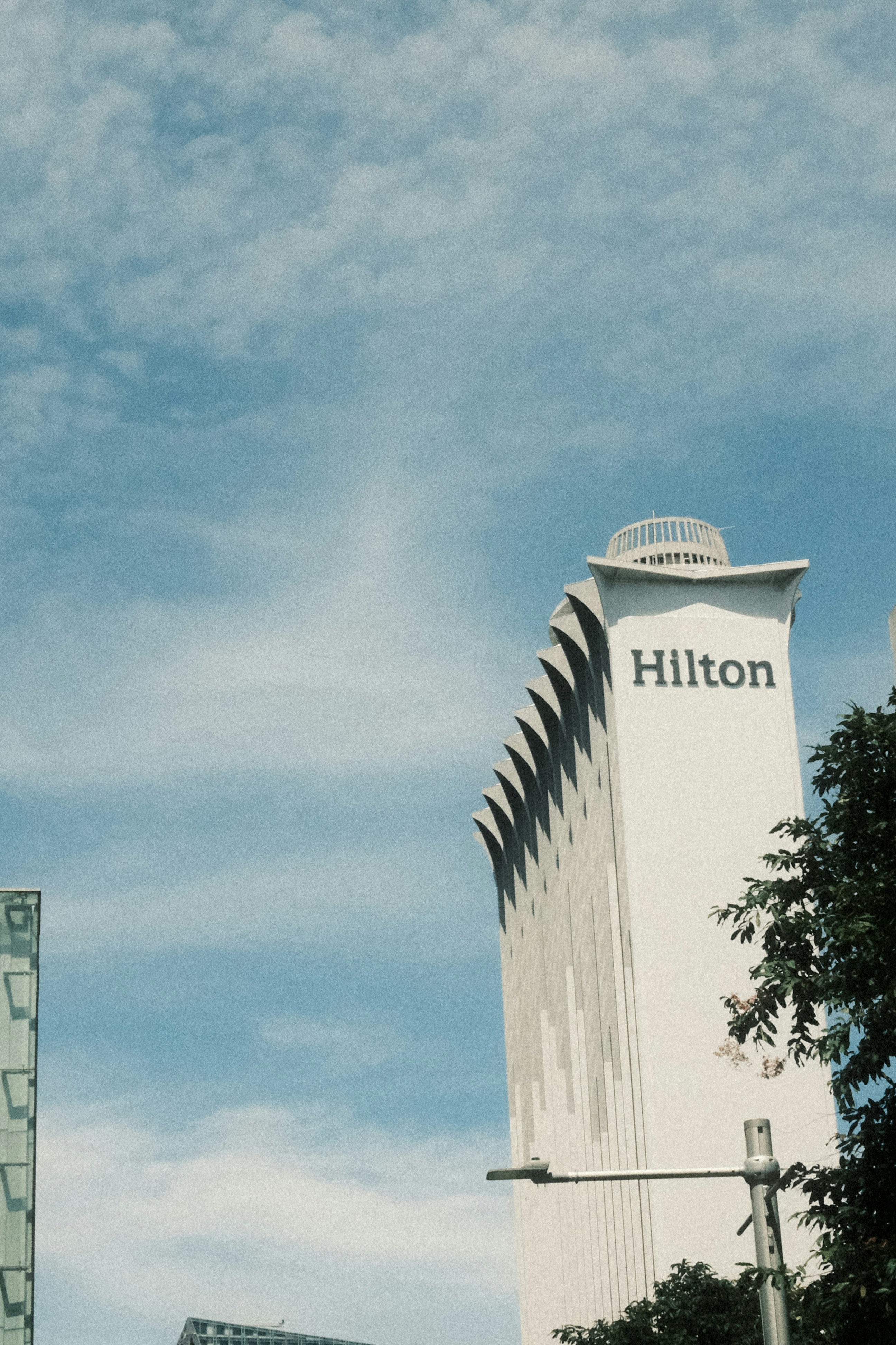 Hilton hotel building against a cloudy blue sky photo – Free Travel ...