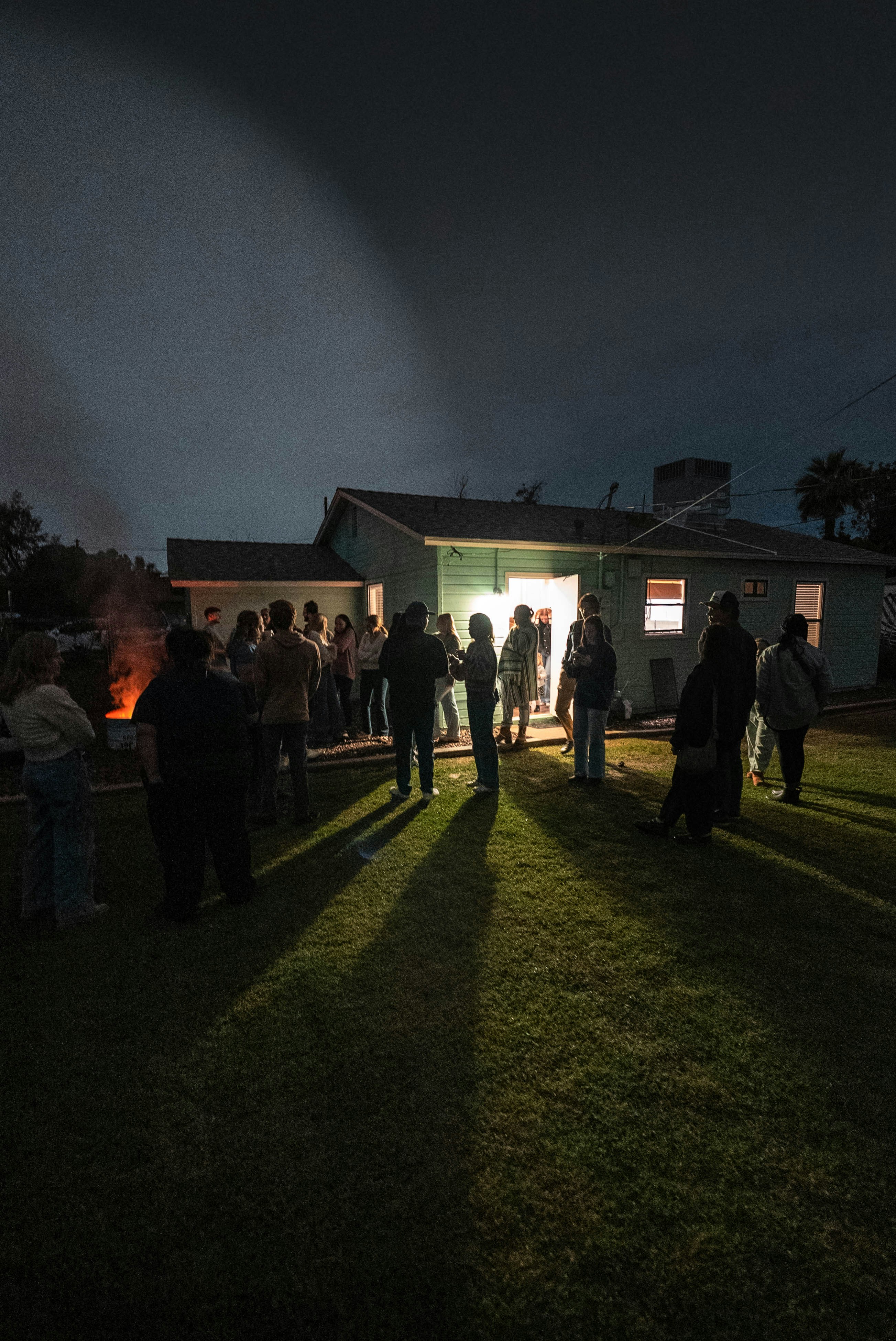 People gathered outside a house at night