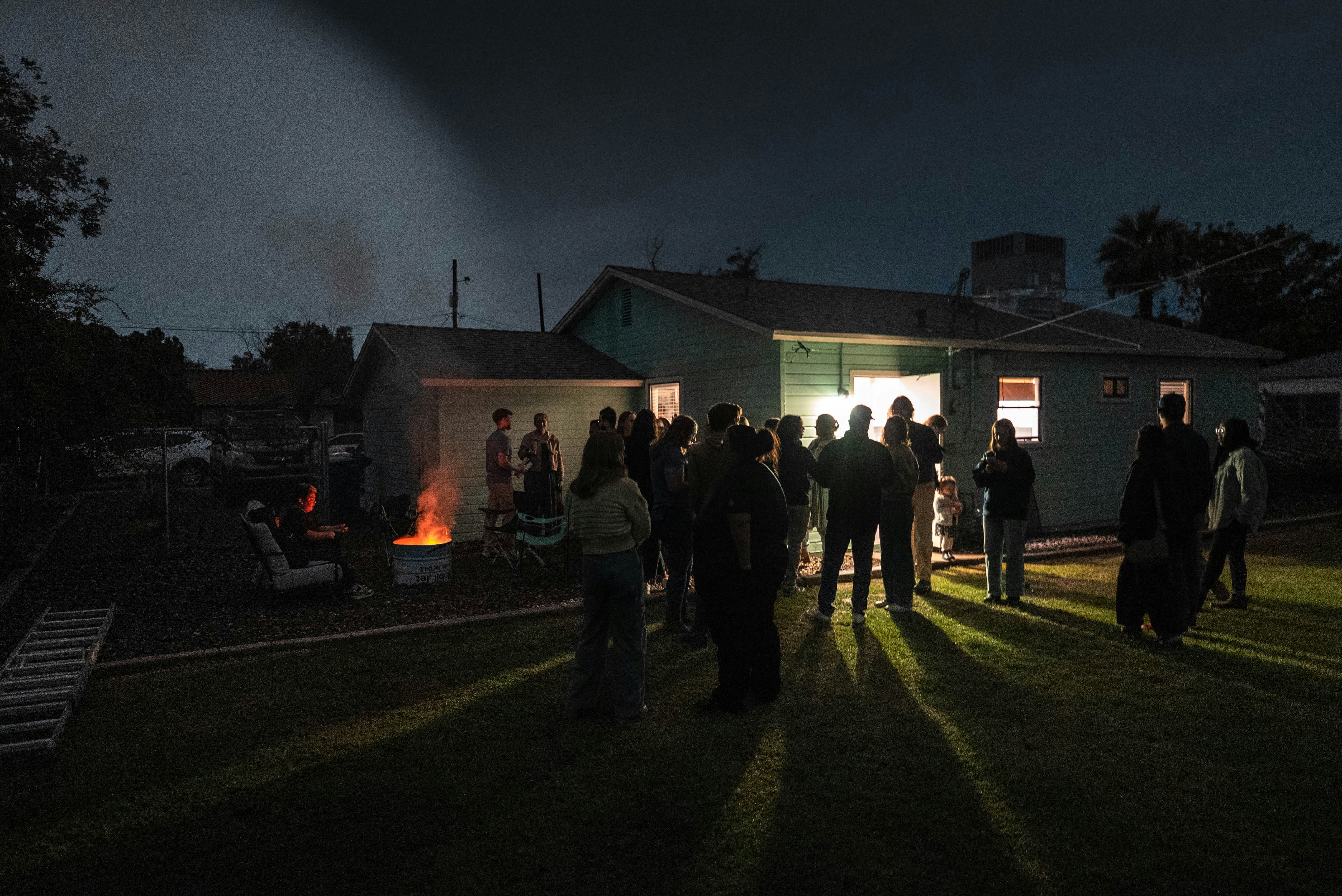 People gathered around a bonfire at night.