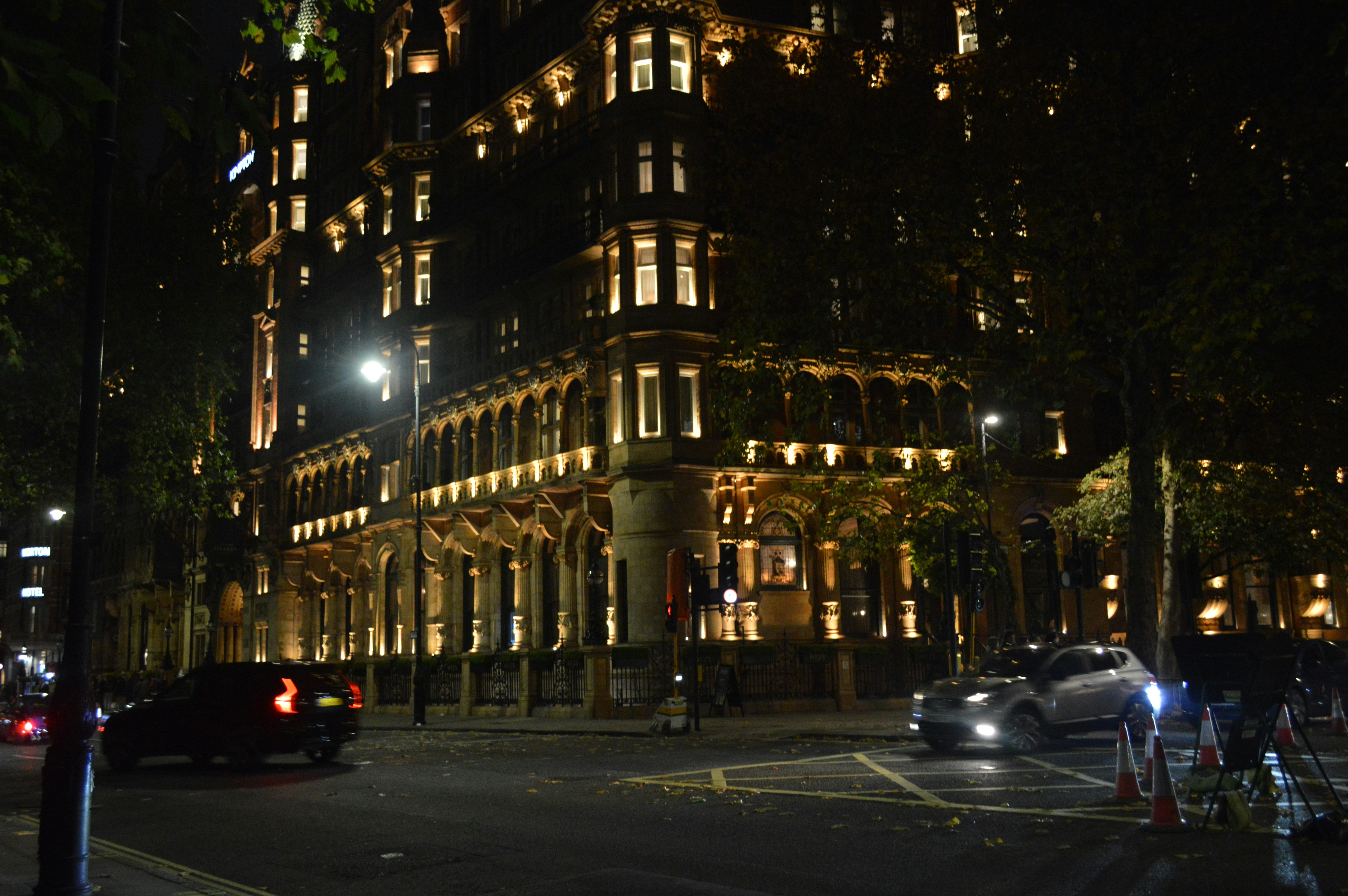 Ornate building illuminated at night with cars passing
