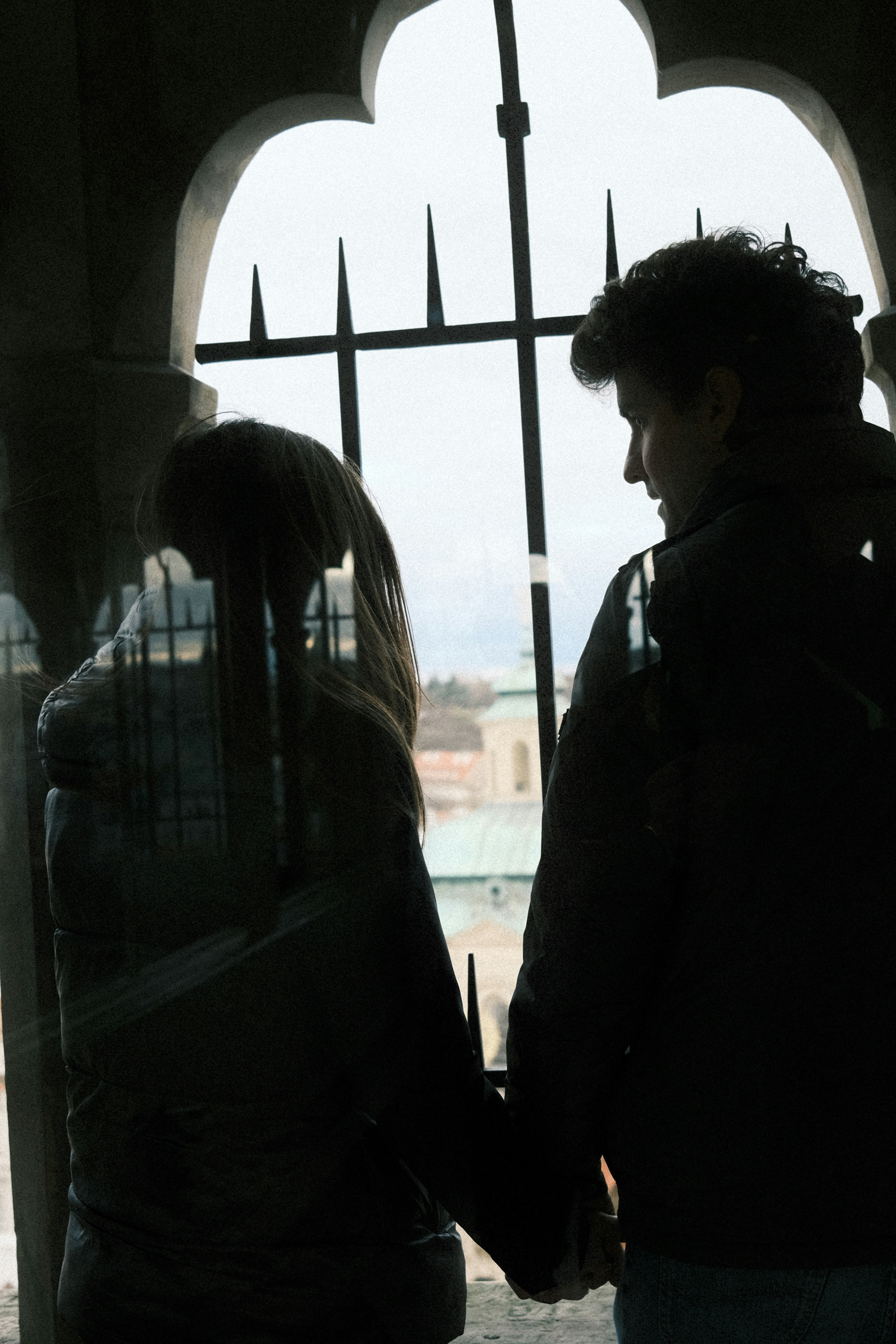 Couple holding hands looking out window