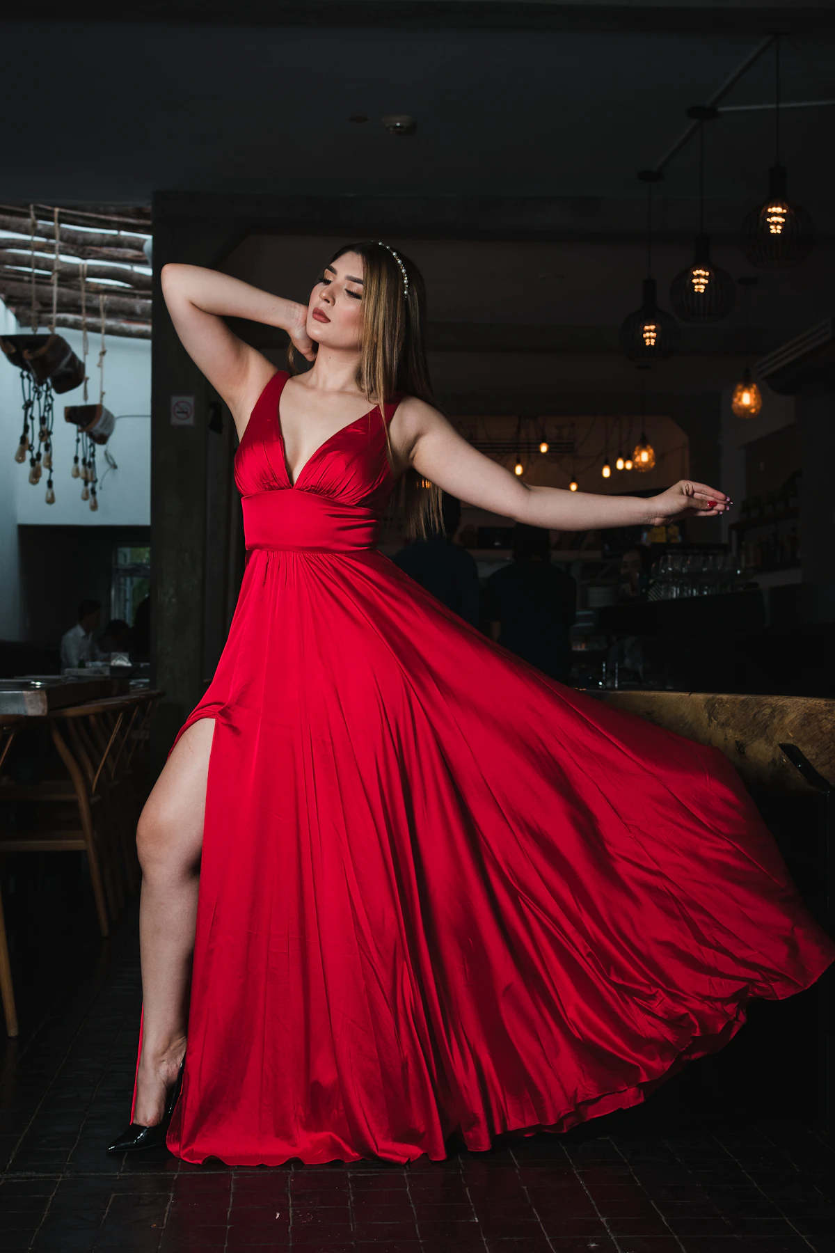 Woman in a flowing red maxi dress with a side slit